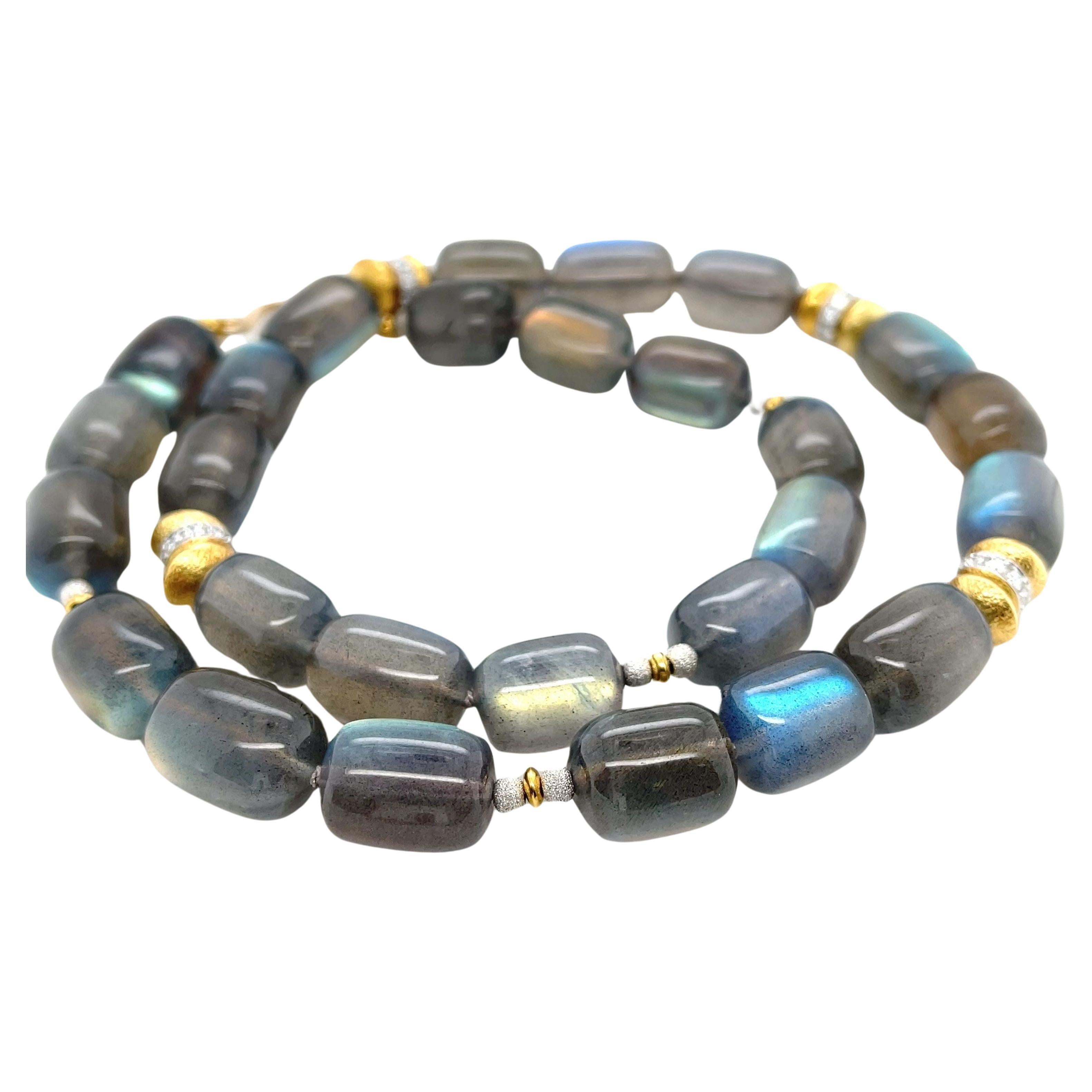 This original necklace features a beautiful collection of striking labradorite beads accented with diamonds and 18k gold. The gorgeous, elongated drum shaped gems exhibit iridescent flashes of blue, green, yellow and orange, an exciting phenomenon
