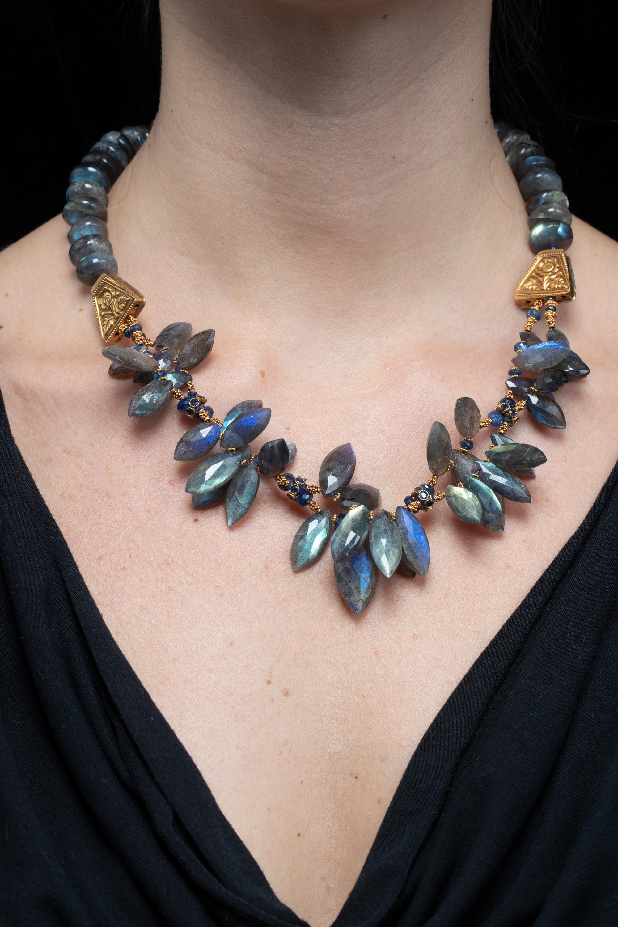 A cluster of faceted marquise-shaped labradorite stones, blue sapphires and 22K gold comprise this beaded necklace.   The Labradorite is a beautiful blue/gray color with great fire to the stones.  Faceted blue sapphires along with 22K gold