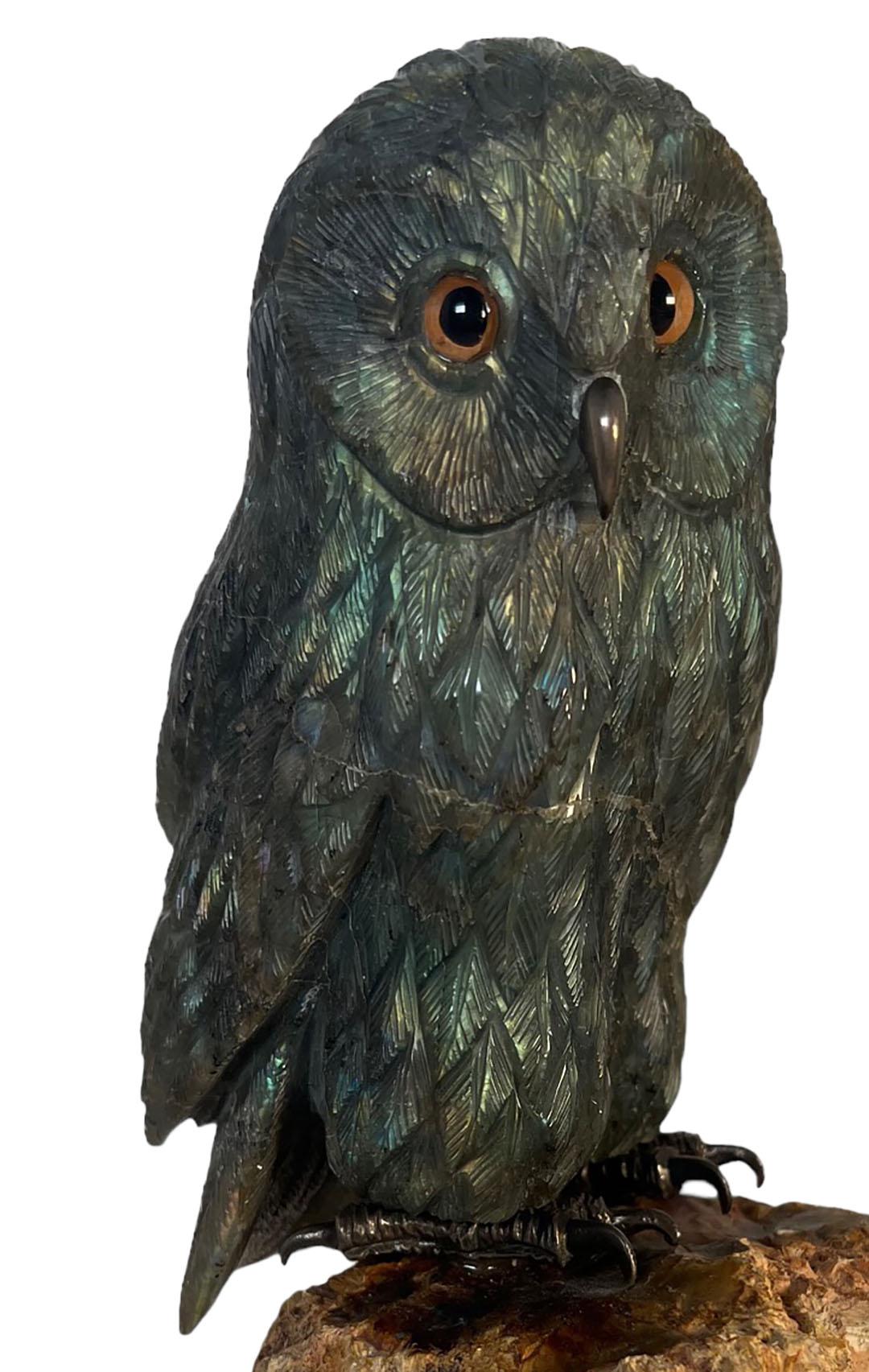 Hibou sculpté en labradorite avec des yeux en verre, perché sur une base en pierre.  Américain, 20e siècle.  
