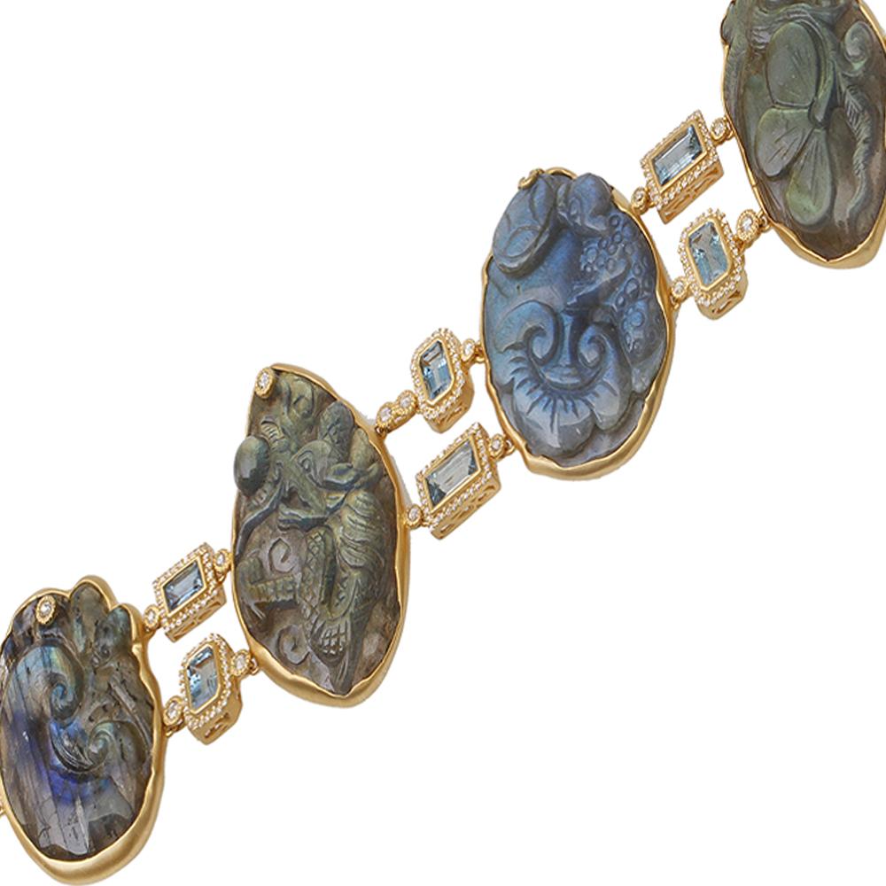 Affinity Bracelet Set in 20 Karat Yellow Gold with 187.11-carat Labradorite Carving, 4.18-carat Aquamarine, 0.56-carat Pink Sapphire, and 0.55-carat Orange Sapphire. This bracelet is set with Emerald-cut Aquamarine between each piece of Carved