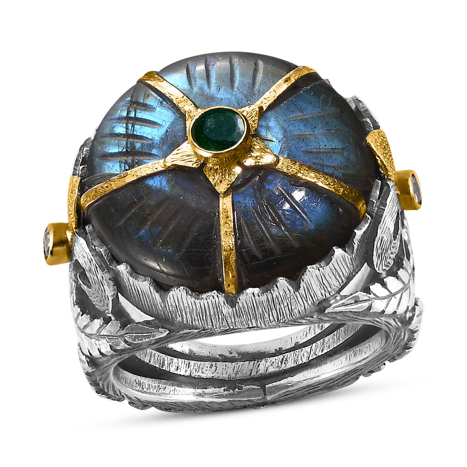 Cette magnifique bague cocktail en labradorite est unique et a été réalisée à la main dans nos ateliers,

La bague comporte une pierre centrale en labradorite sculptée à la main, incrustée d'une émeraude et flanquée de diamants pleine taille. La