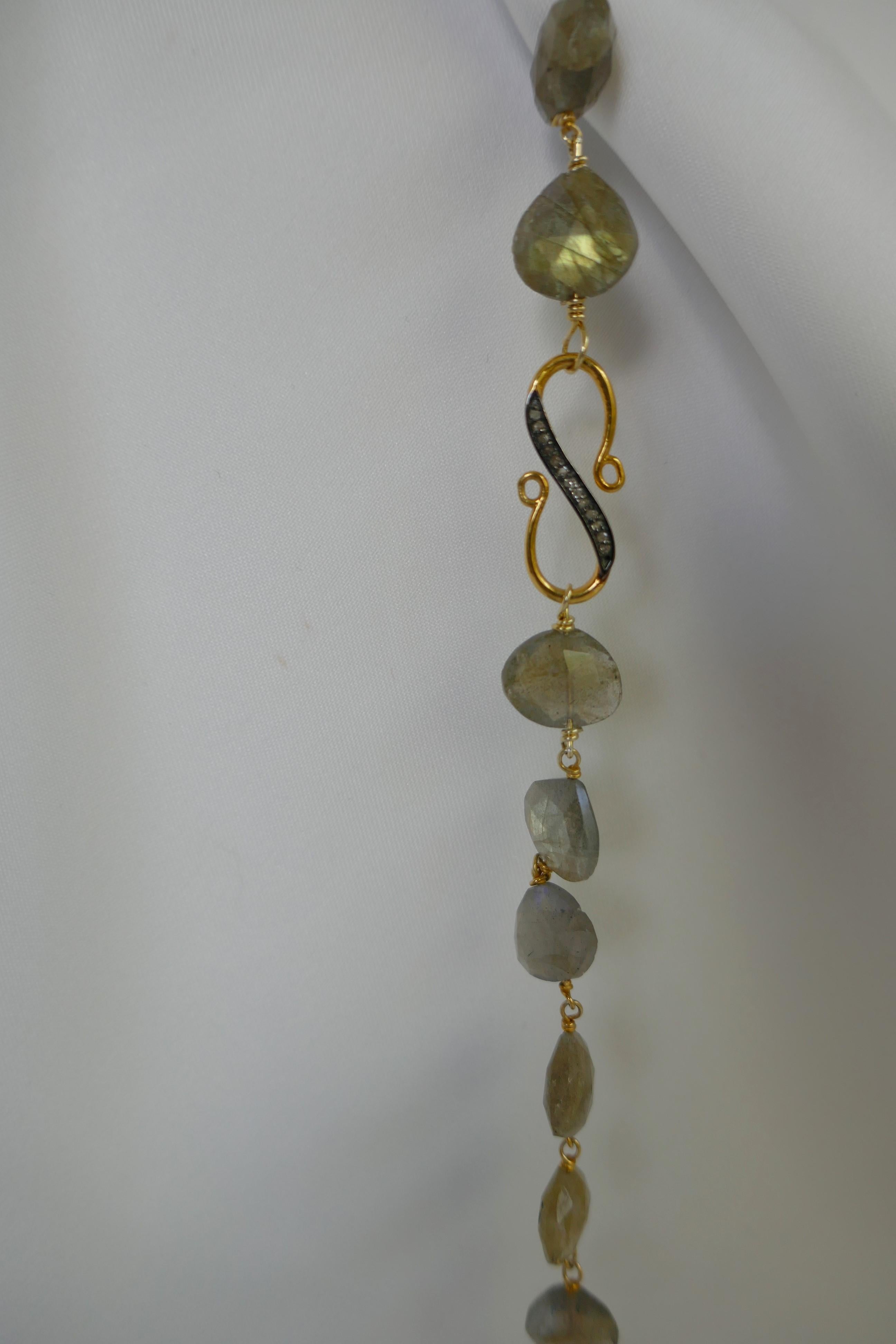 This is a basket cut faceted labradorite long necklace that may be worn long, doubled or layered with an S shaped diamond clasp plated in 18k gold.  The necklace is 49.5 inches long. The iridescent in the labradorite stone is beautiful. The