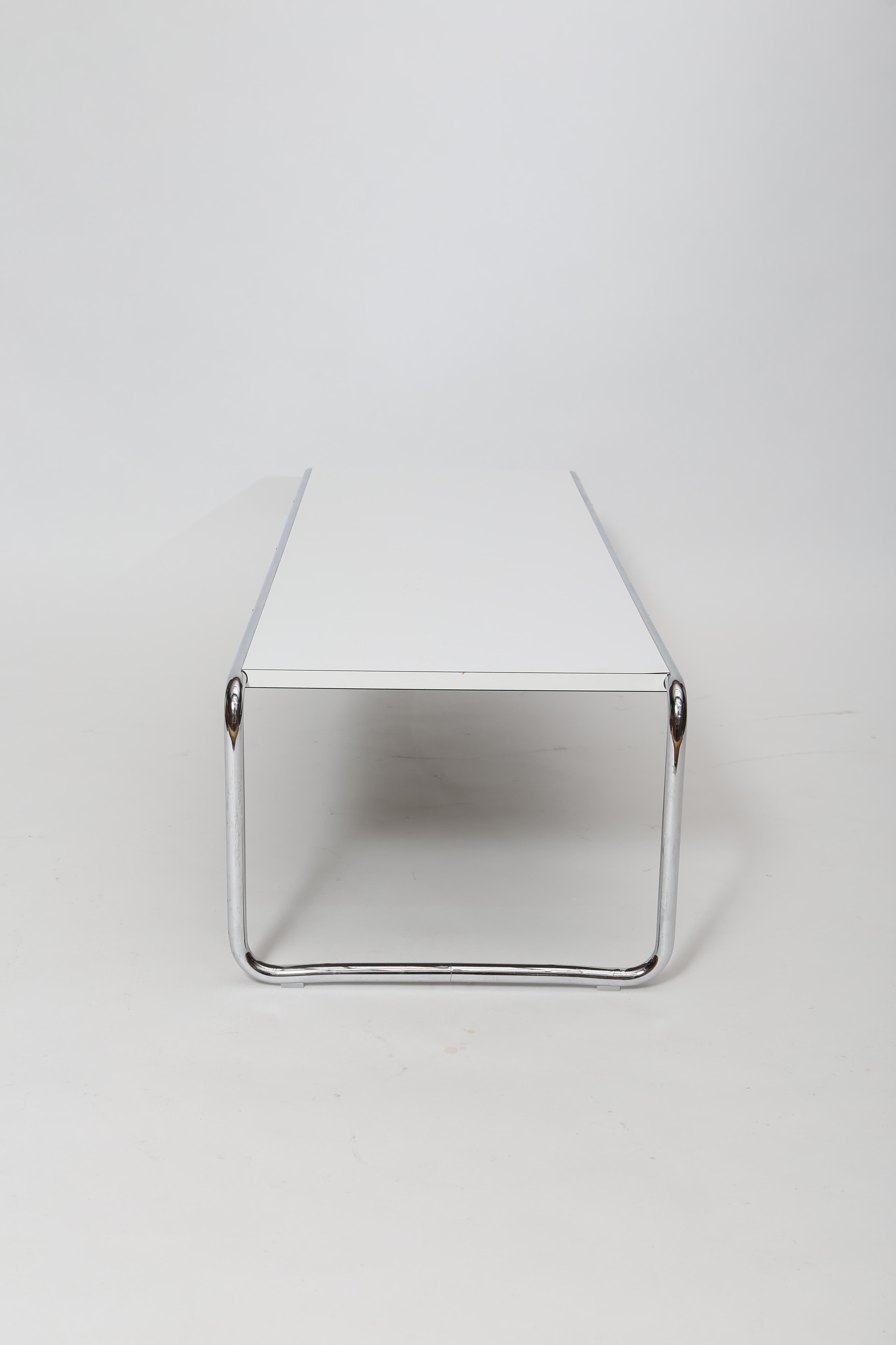 Marcel Breuer’s designs are enduring and the Laccio coffee table is no exception. Constructed of chromed steel tubing with a white laminated mdf core top, this table has a nice scale and effortless chic appeal. In excellent condition with little to