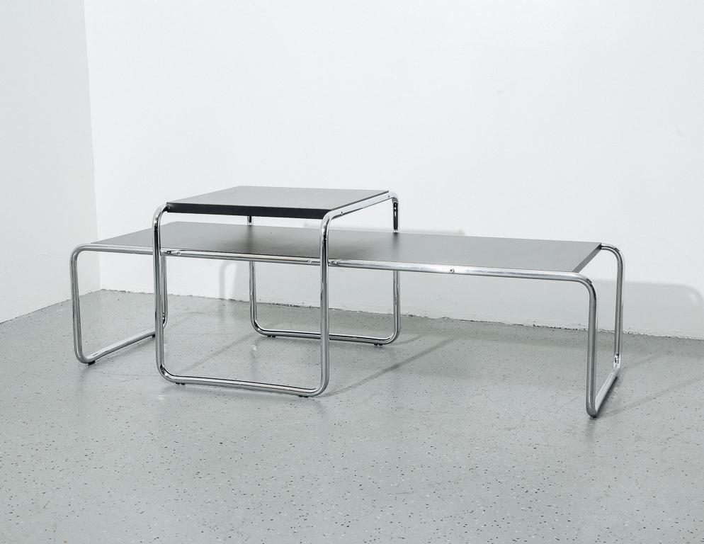Classic Bauhaus design. Chrome tubular frame with black laminate tops. Includes nesting coffee table and end table. Attributed to Marcel Breuer.