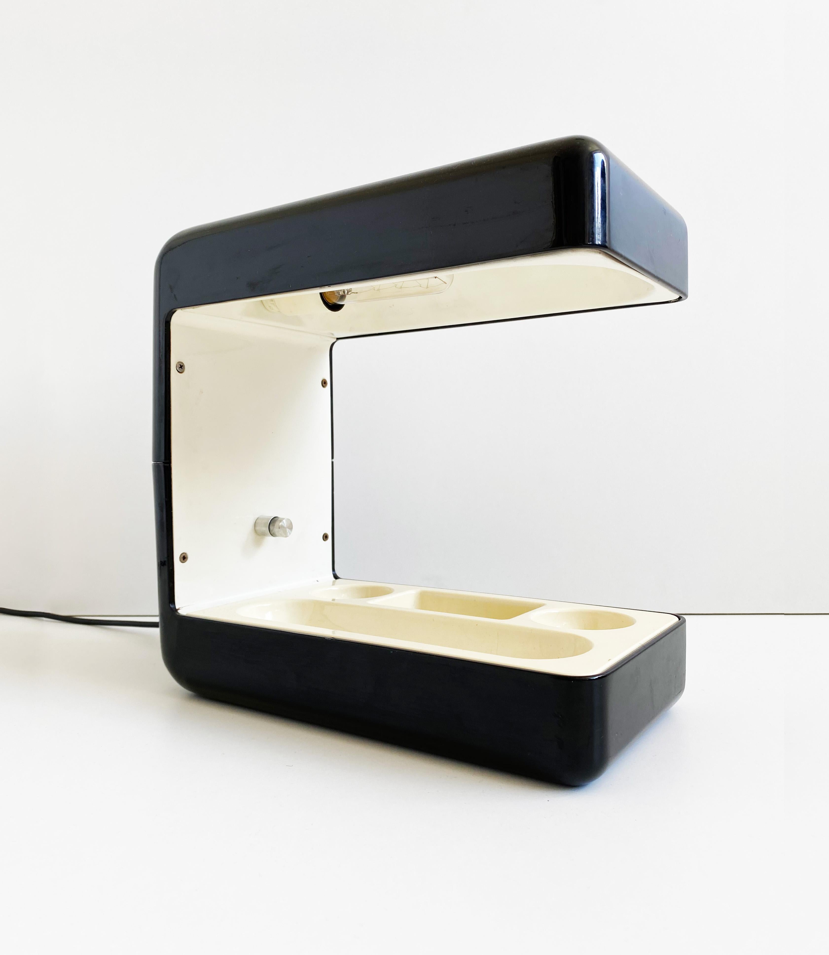 Superb desk lamp, come desk tidy, designed by Giotto Stoppino and manufactured by Tronconi in the 70s. The lamp is formed from a black lacquered aluminium shell with a cream ABS desk tidy insert and a brushed aluminium switch

Condition: Great