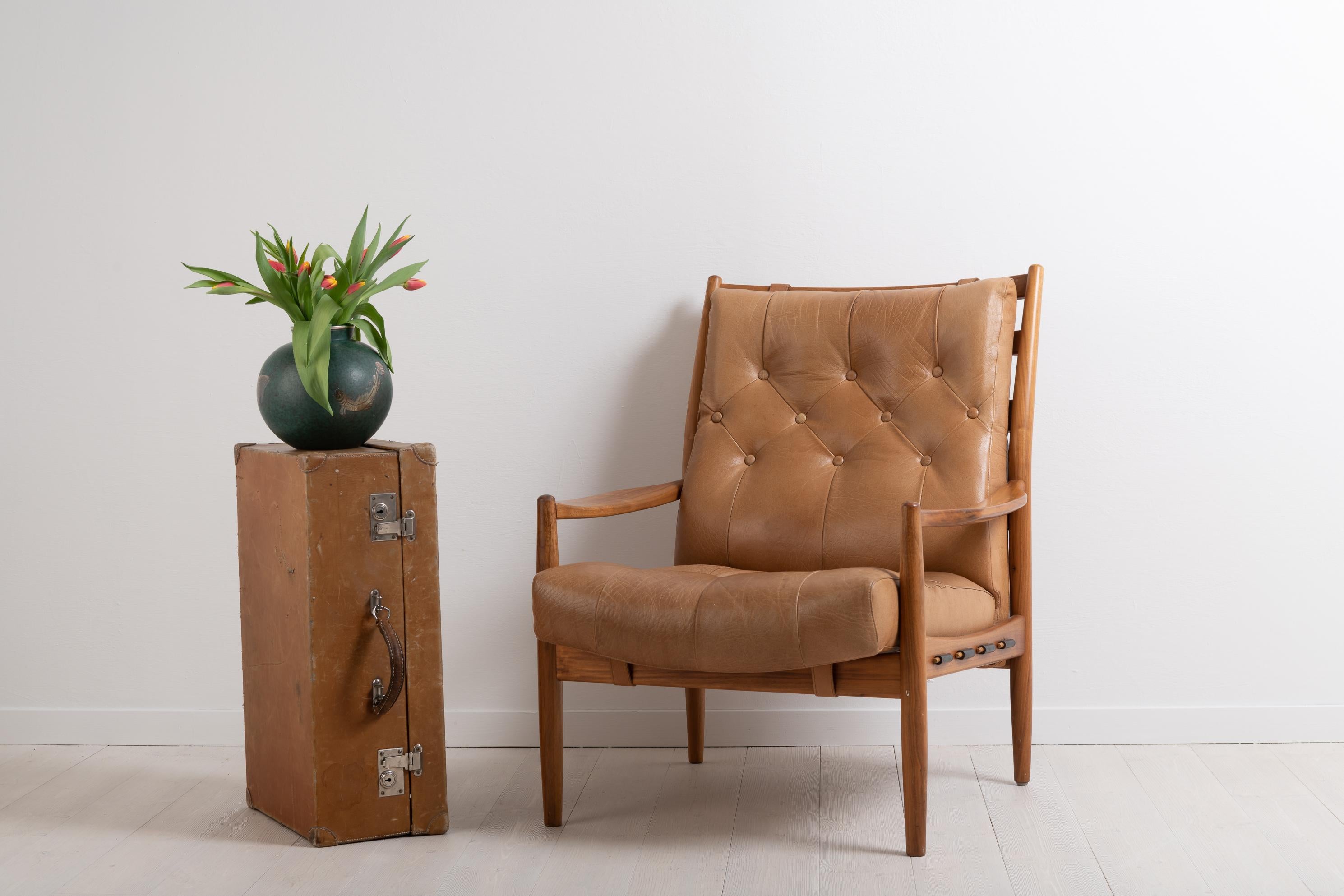 “Läckö Hög” by Swedish designer Ingemar Thillmark. The armchair is manufactured by OPE furniture, Olof Persson Möbler, in Jönköping during the second half of the 20th century. The frame is made from stained beech and the armchair has two loose