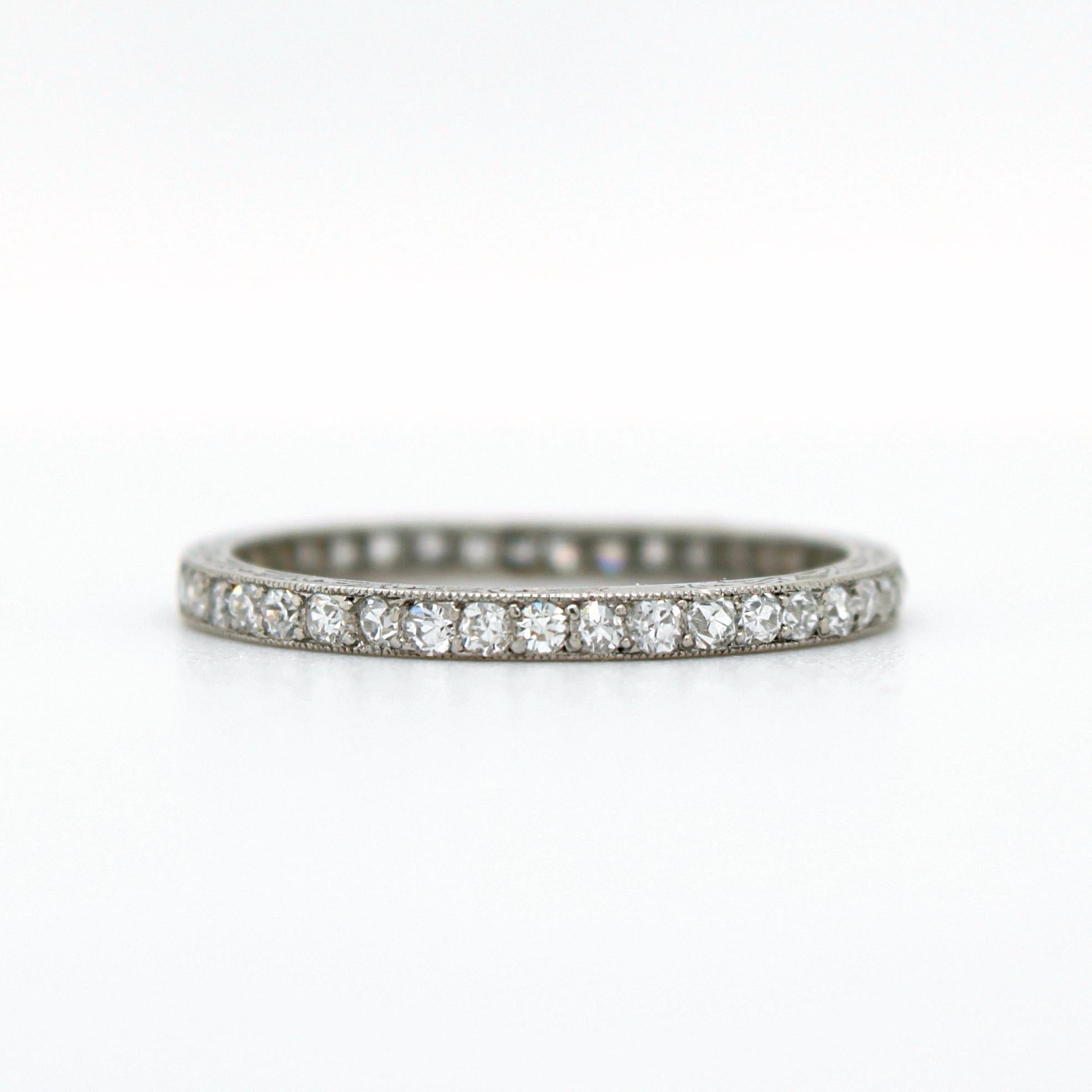 A lovely diamond eternity wedding band ring by Lacloche Frères - Paris, France, ca. 1910s. 
The ring has a lot of character. It is very finely set with small old cut diamonds throughout and the ring profile has an intricate carved design, both of