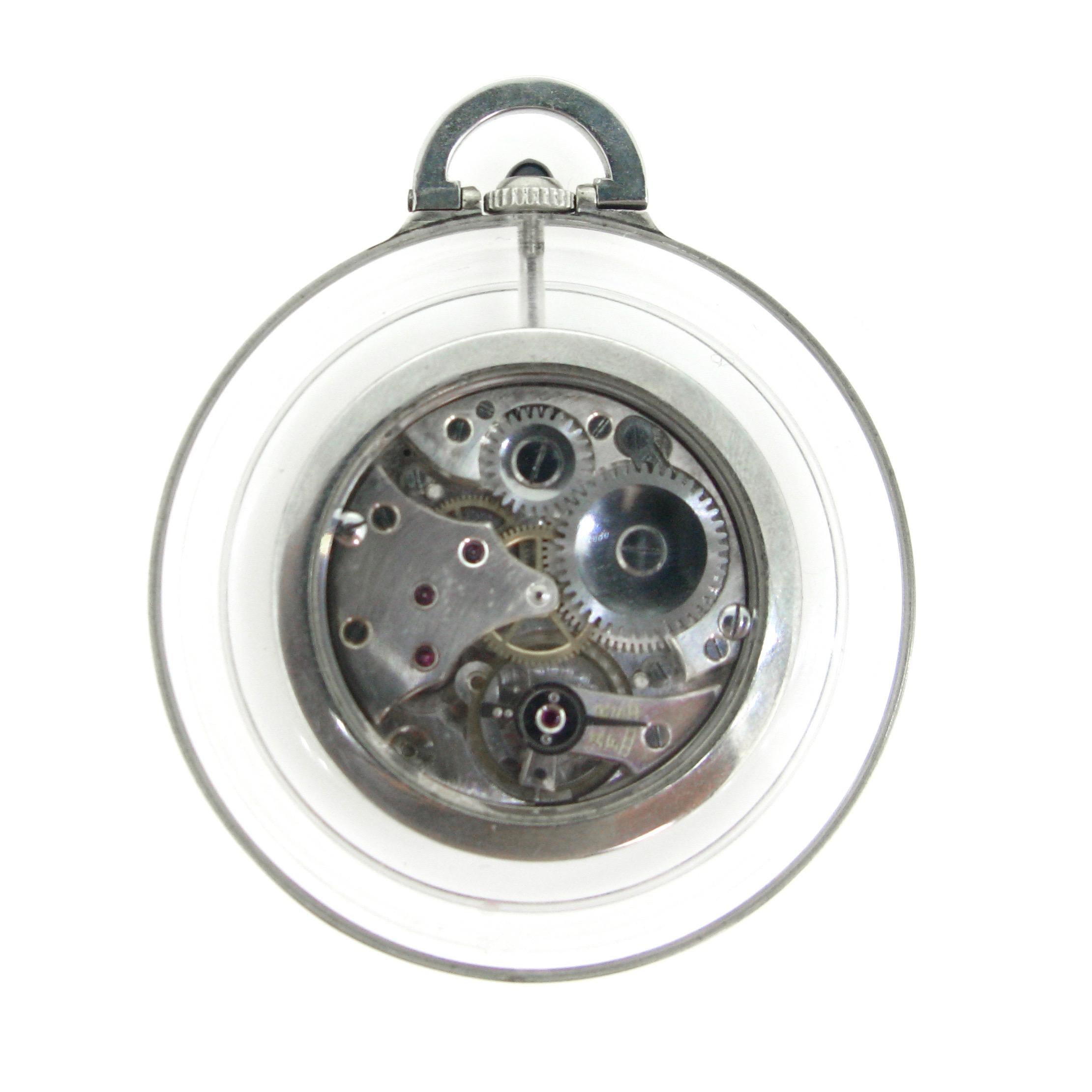 This Art Deco pocket watch is set within a reeded Crystal Rock circular frame. The winding crown is set with a cabochon sapphire. It is signed Lacloche. The movement is visible through the back of the watch.  The movement is a manual wind and it is
