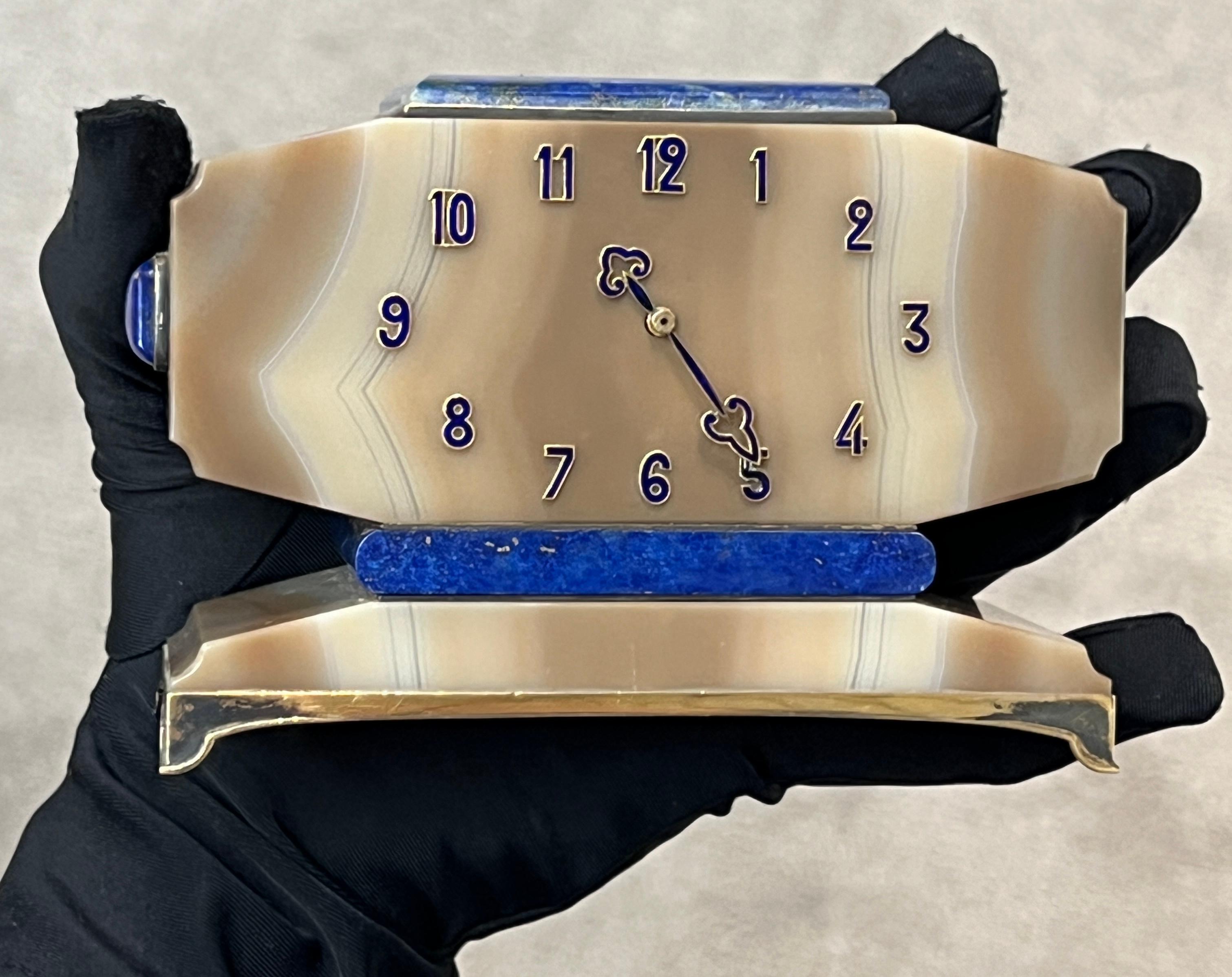Lacloche Freres Art Deco-Schreibtischuhr

Eine Art-Deco-Tischuhr von LaCloche Frères, hergestellt aus Achat, Gold, Silber und Lapislazuli. Zeiger und Zahlen aus 18 Karat Gold mit blauer Emaille. Montiert auf einem Sockel aus Sterlingsilber mit