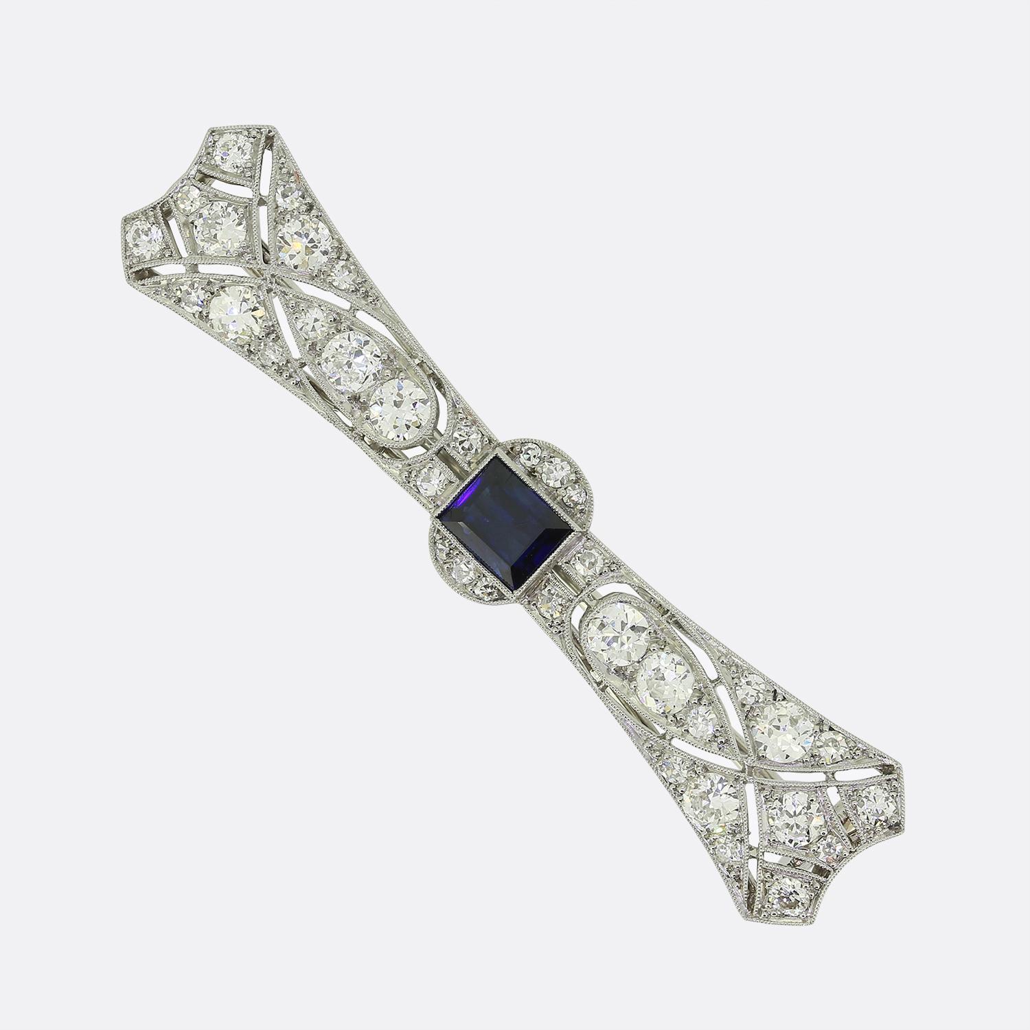 This is an Art Deco sapphire and diamond brooch from the luxury French jewellery designer LaCloche Frères. The brooch is crafted in platinum and the central sapphire is a mid to dark blue hue. The darker tone of the sapphire emphasises the bright