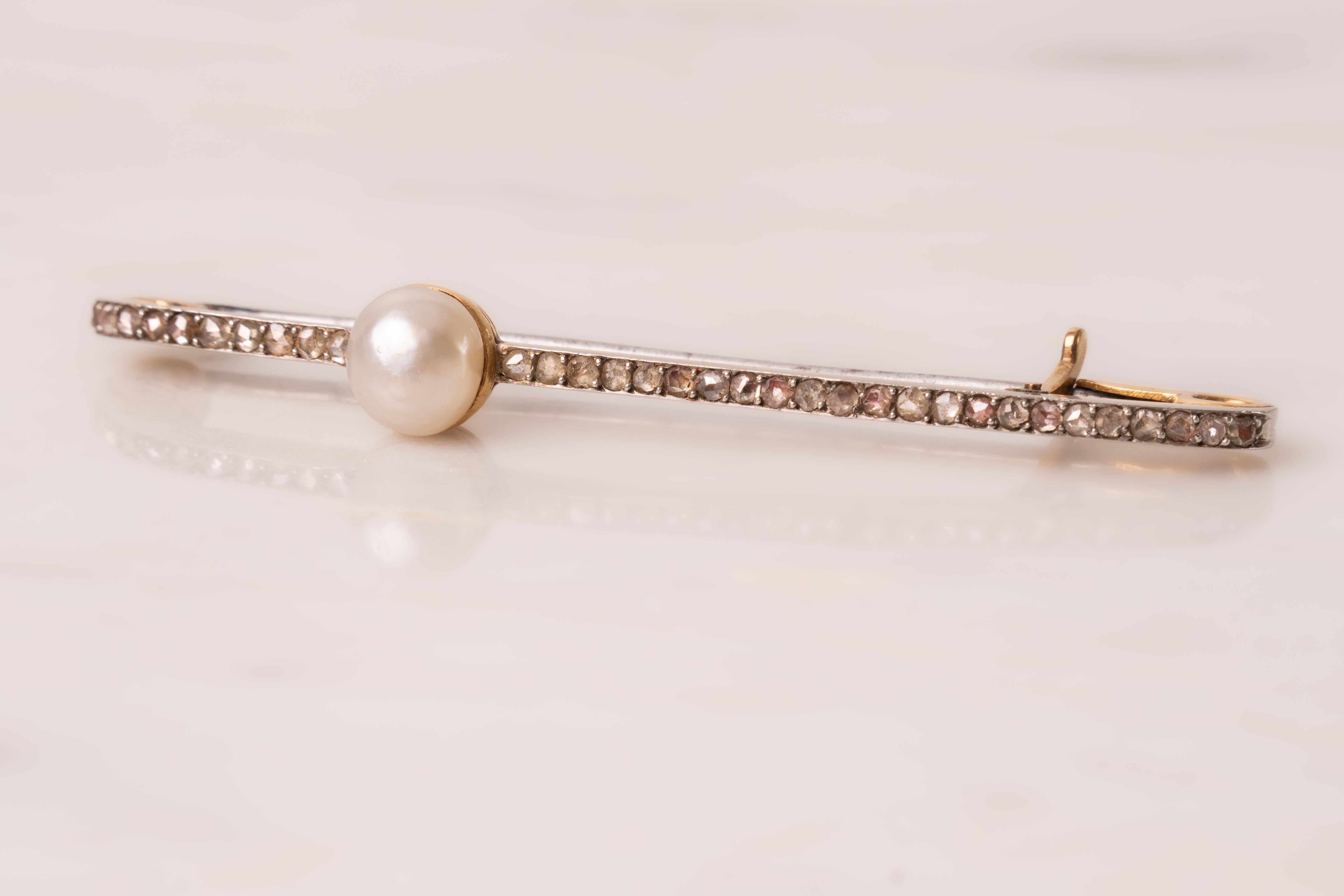 Spilla a barra con diamante taglio rosa e perla asimmetrica decentrata, in oro e forse in argento. La perla non è stata testata, il pezzo è marchiato La Cloche Paris, in riferimento alla rinomata casa di gioielli parigina che ha operato dal 1892 al