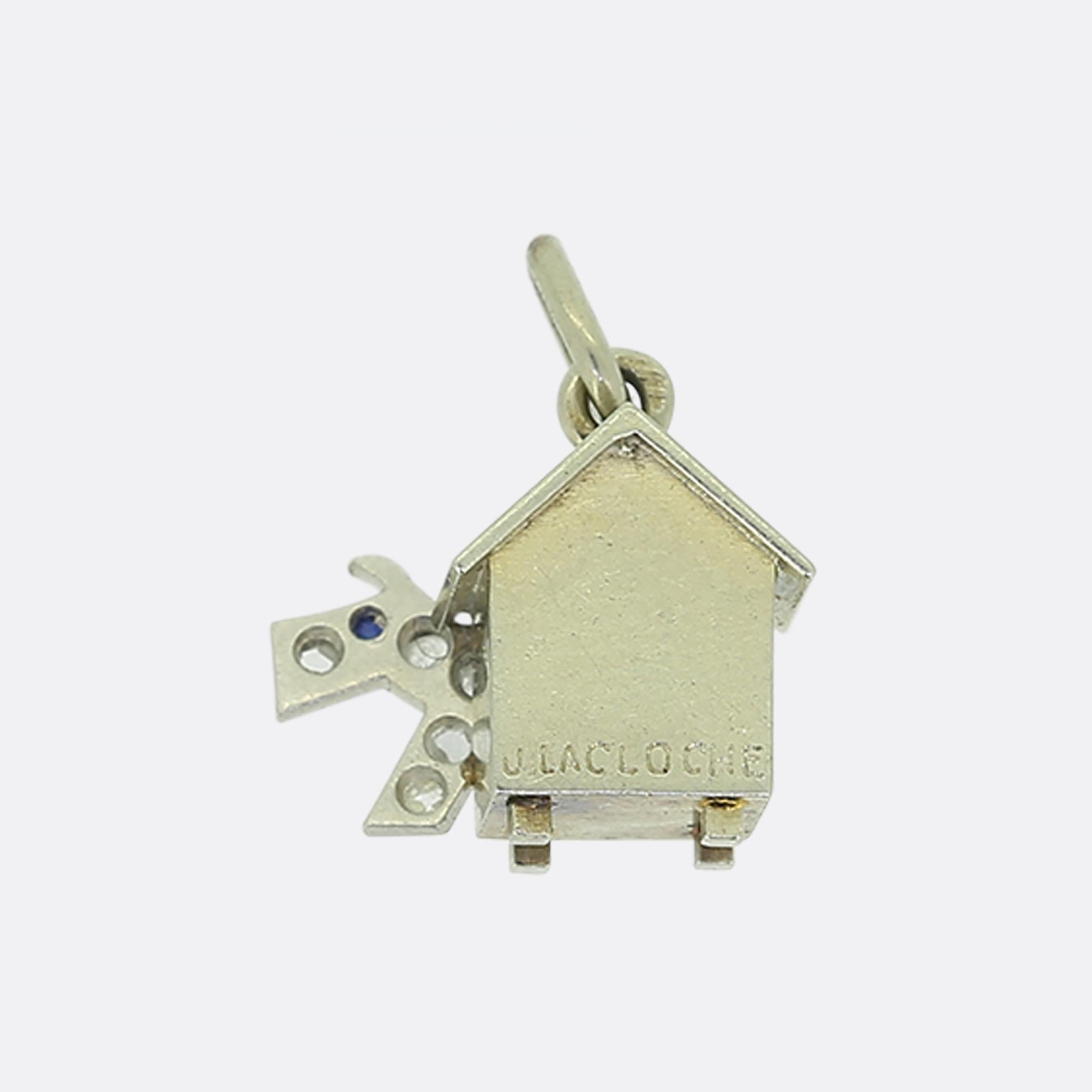 Aquí tenemos un divertido y original colgante Art Decó de la prestigiosa casa de joyería de lujo LaCloche. Esta pieza se ha elaborado en oro blanco de 18 ct con la forma de una caseta de perro junto a un perro engastado con zafiros y diamantes talla