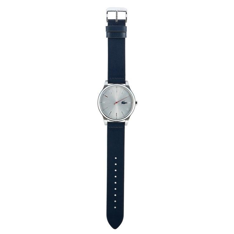 This is the Lacoste Kyoto watch, reference number 2011000. It is presented with a stainless steel case that measures 43 mm in diameter. The case is water-resistant to 50 meters and mounted onto a blue leather strap, secured on the wrist with a tang