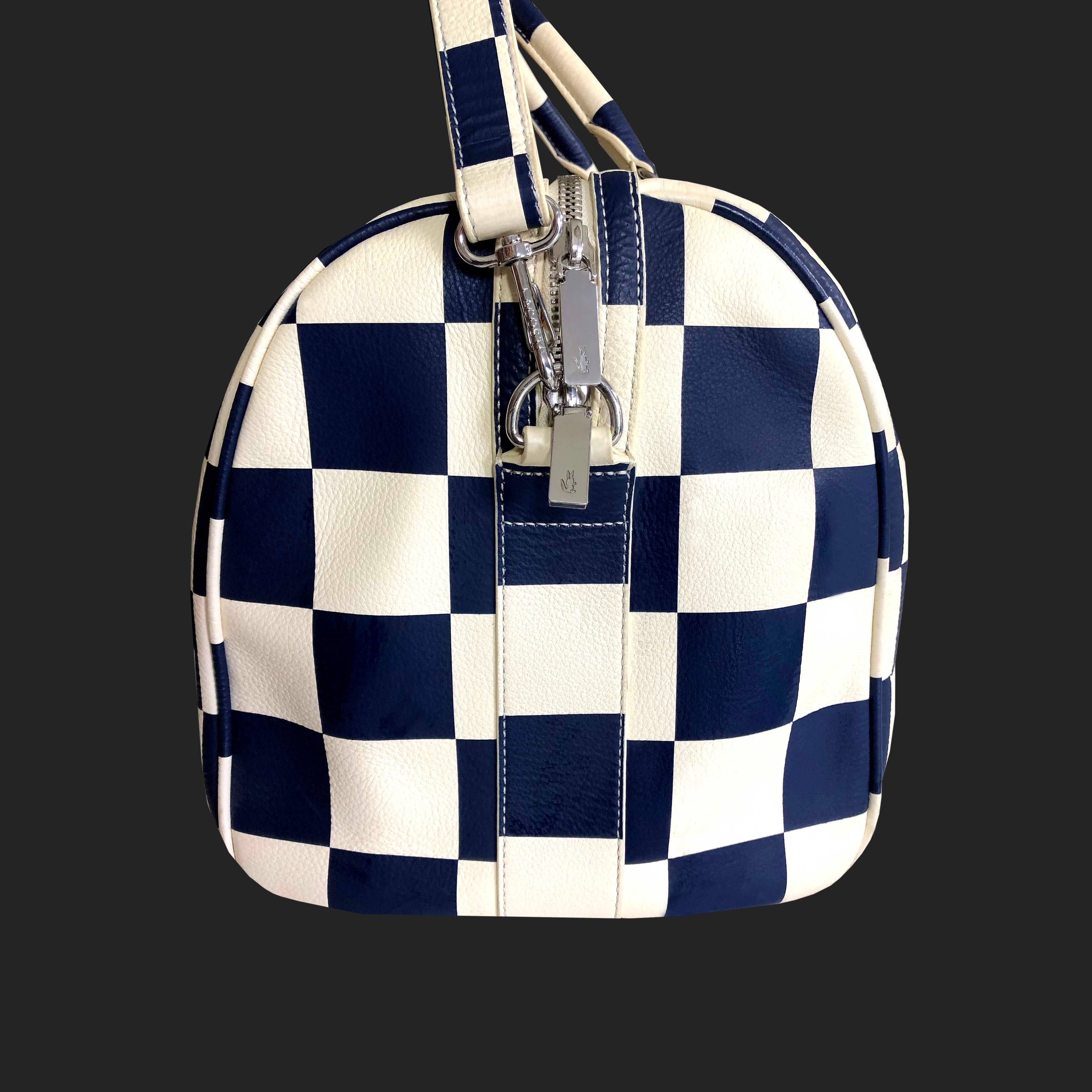 Product Details: Lacoste - Leather Weekend / Gym Bag - Cream + Navy Blue Check Leather + Metal Lacoste Logo - Leather Piping Edging Throughout - Detachable Shoulder Strap - Silver ‘Lacoste’ Logo Hardware Throughout - Padded Handles - Navy Cotton