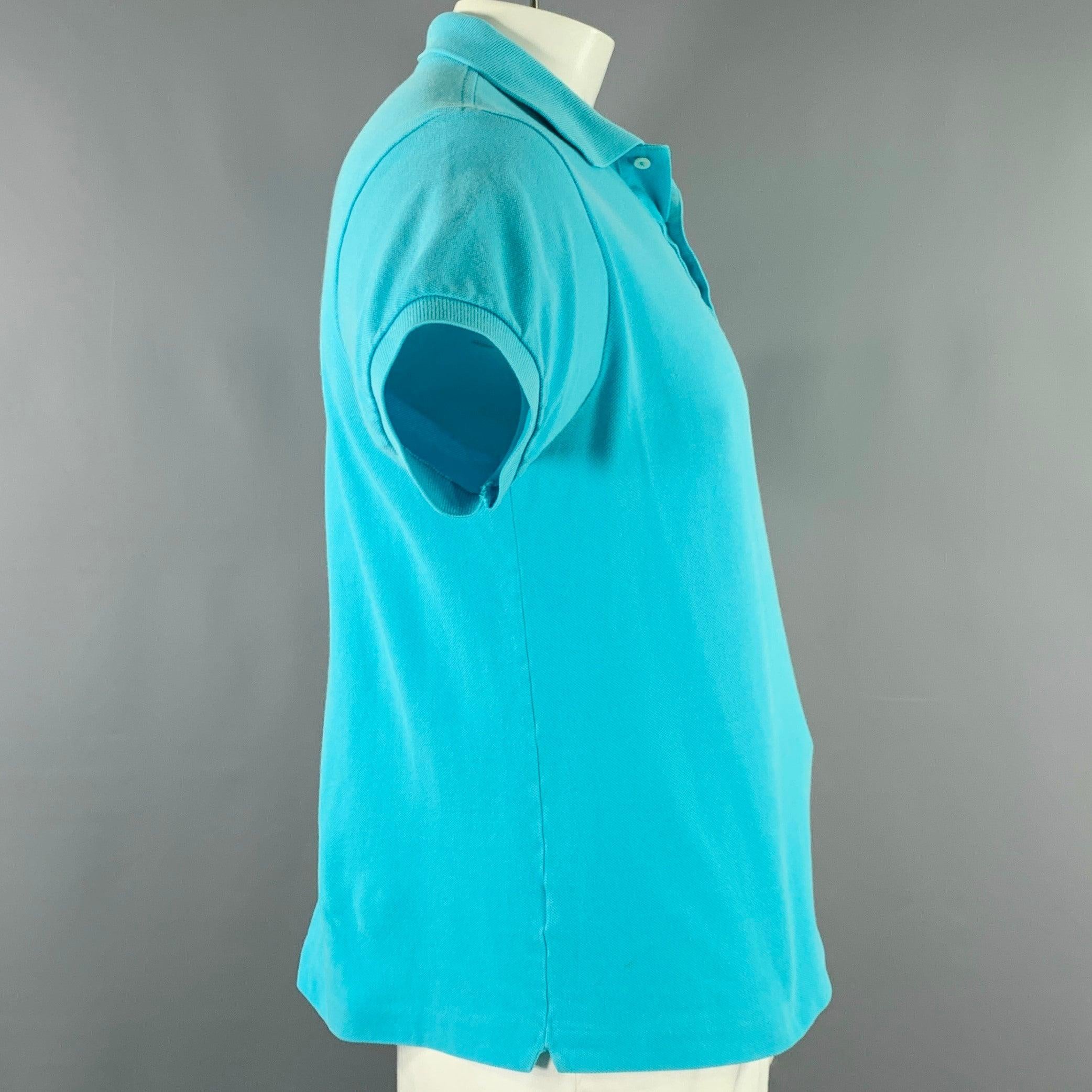 LACOSTE polo
aus aqua-blauer Baumwolle mit grünem Alligator-Logoaufnäher und halber Knopfleiste in gutem, gebrauchtem Zustand. Mäßige Spuren, so wie sie sind. 

Markiert:   5 

Abmessungen: 
 
Schultern: 18,5 Zoll Brustumfang: 42 Zoll Ärmelumfang: 8