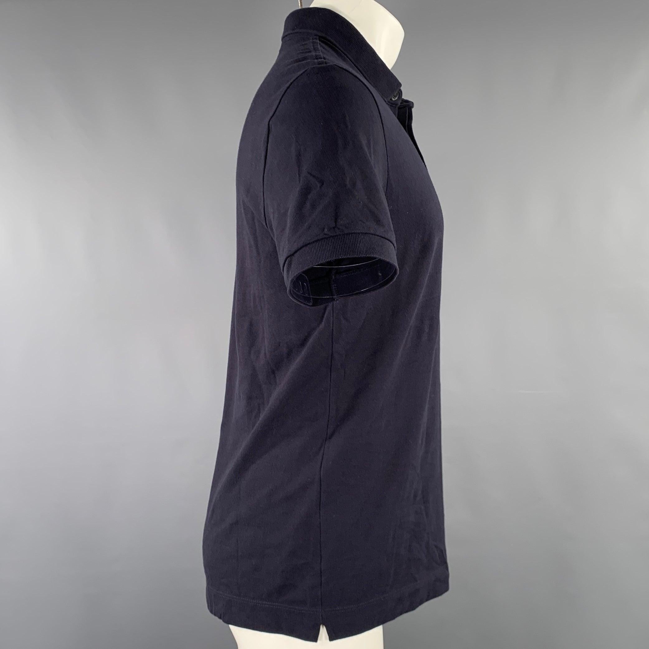 Polo Lacoste
in tessuto misto cotone elasticizzato color navy, con vestibilità regolare e chiusura con bottoni a metà abbottonatura nascosta. Eccellente condizione di usato. 

Contrassegnato:   FR 4 

Misure: 
 
Spalla: 17,5 pollici Petto: 38