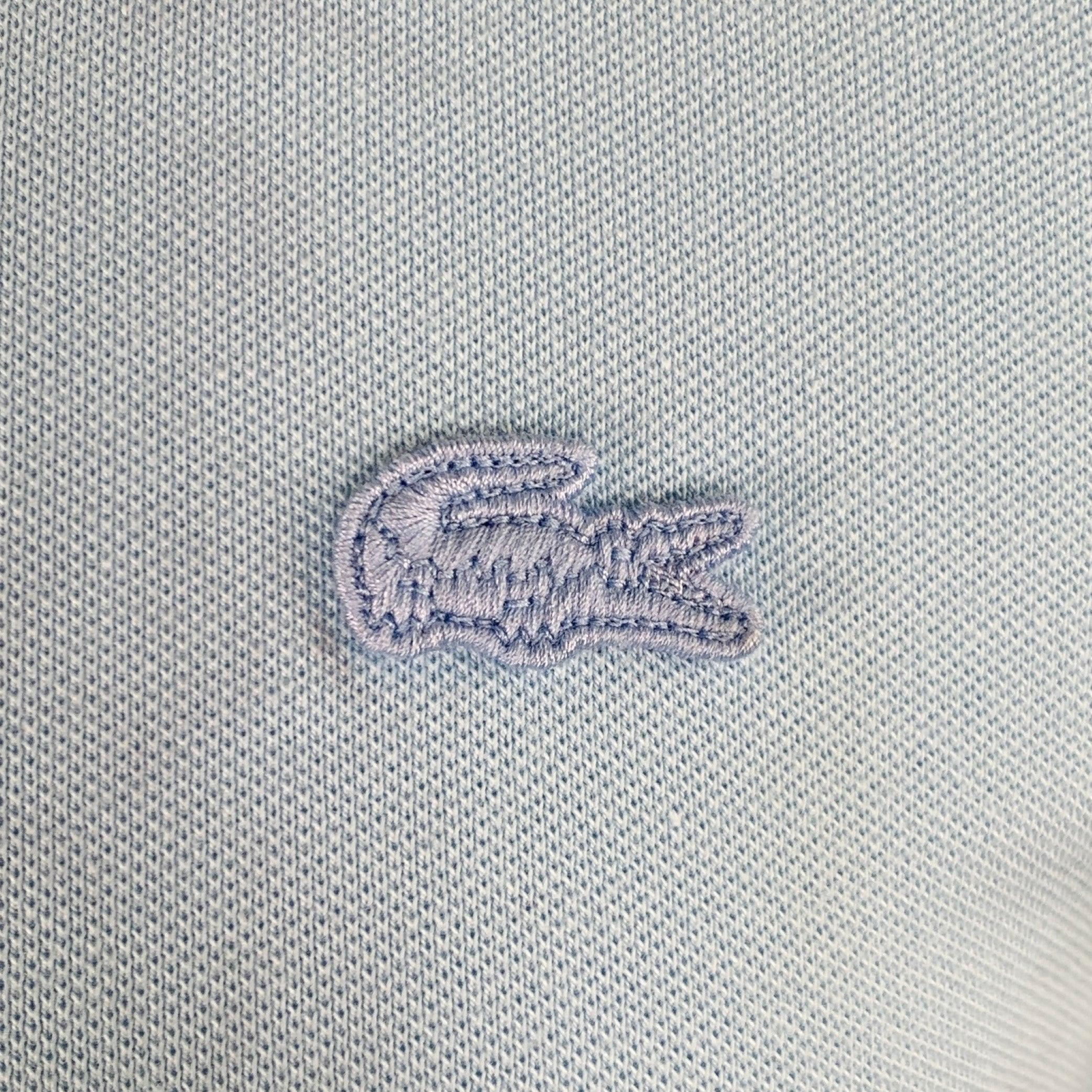 Polo LACOSTE en coton bleu avec logo alligator bleu assorti et demi-patte boutonnée. Bon état d'origine. Marque modérée sur le devant. En l'état. 

Marqué :   FR 3 

Mesures : 
 
Épaule : 17 pouces Poitrine : 38 pouces Manches : 8.5 pouces Longueur