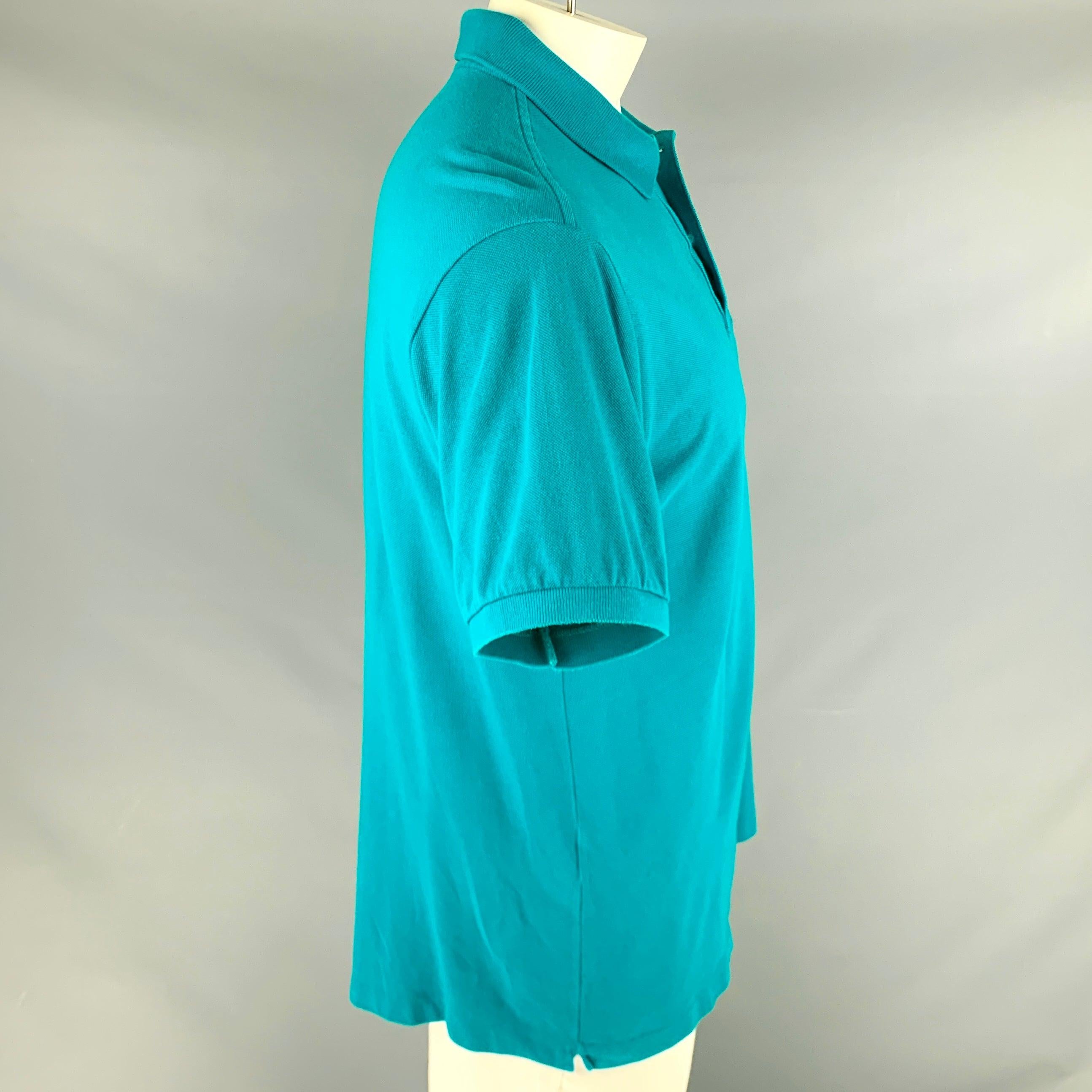 LACOSTE polo
in an aqua blue cotton fabric featuring signature alligator logo, spread collar, and half placket button closure. Made in France.Very Good Pre-Owned Condition. Minor signs of wear. 

Marked:   6 

Measurements: 
 
Shoulder: 19 inches