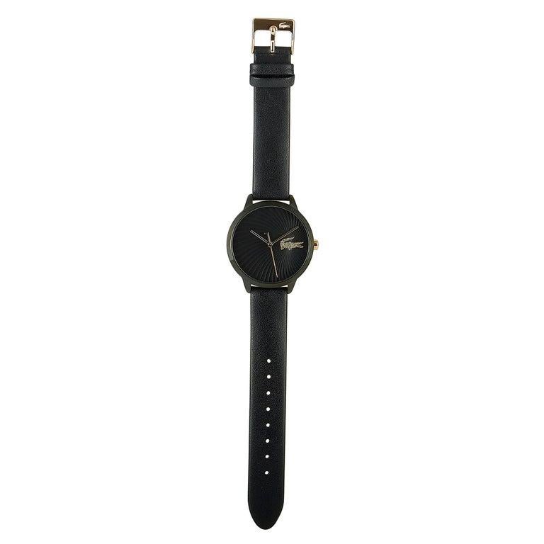 This is the Lacoste Lexi watch, reference number 2001069. It boasts a 38 mm stainless steel case that is presented on a black leather strap, secured on the wrist with a tang buckle. The case is water-resistant to 30 meters. The black dial boasts a
