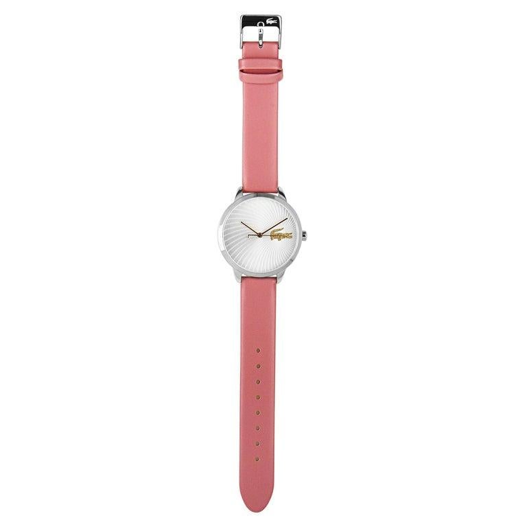 This is the Lacoste Lexi watch, reference number 2001057. It boasts a 38 mm stainless steel case that is presented on a pink leather strap, secured on the wrist with a tang buckle. The case is water-resistant to 30 meters. The silver dial boasts a