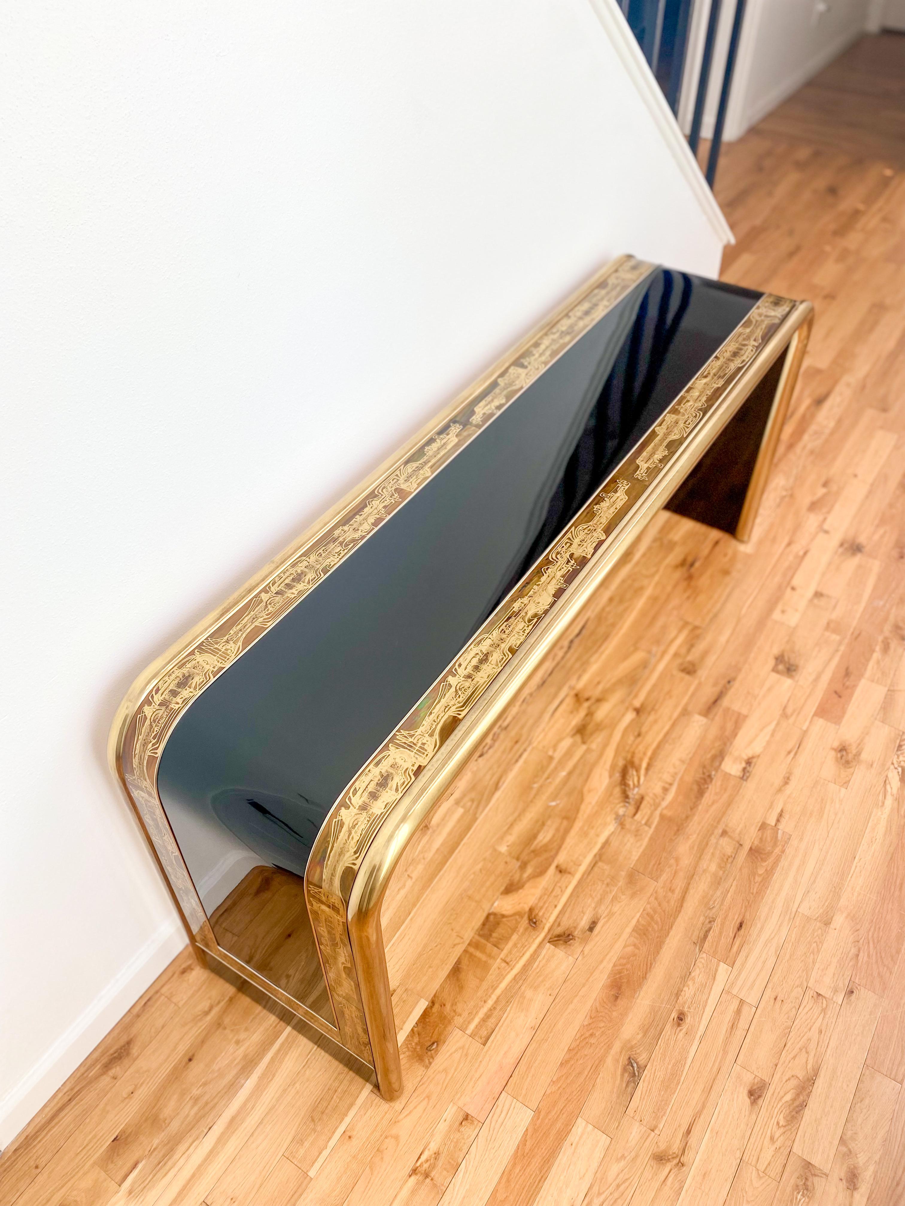 Breathtaking black lacquer waterfall console table with acid-etched brass details by Bernhard Rohne for Mastercraft, c.1970s. This showstopper is sleek and polished, with unique character in the brass tubing and etched panels that you won’t find