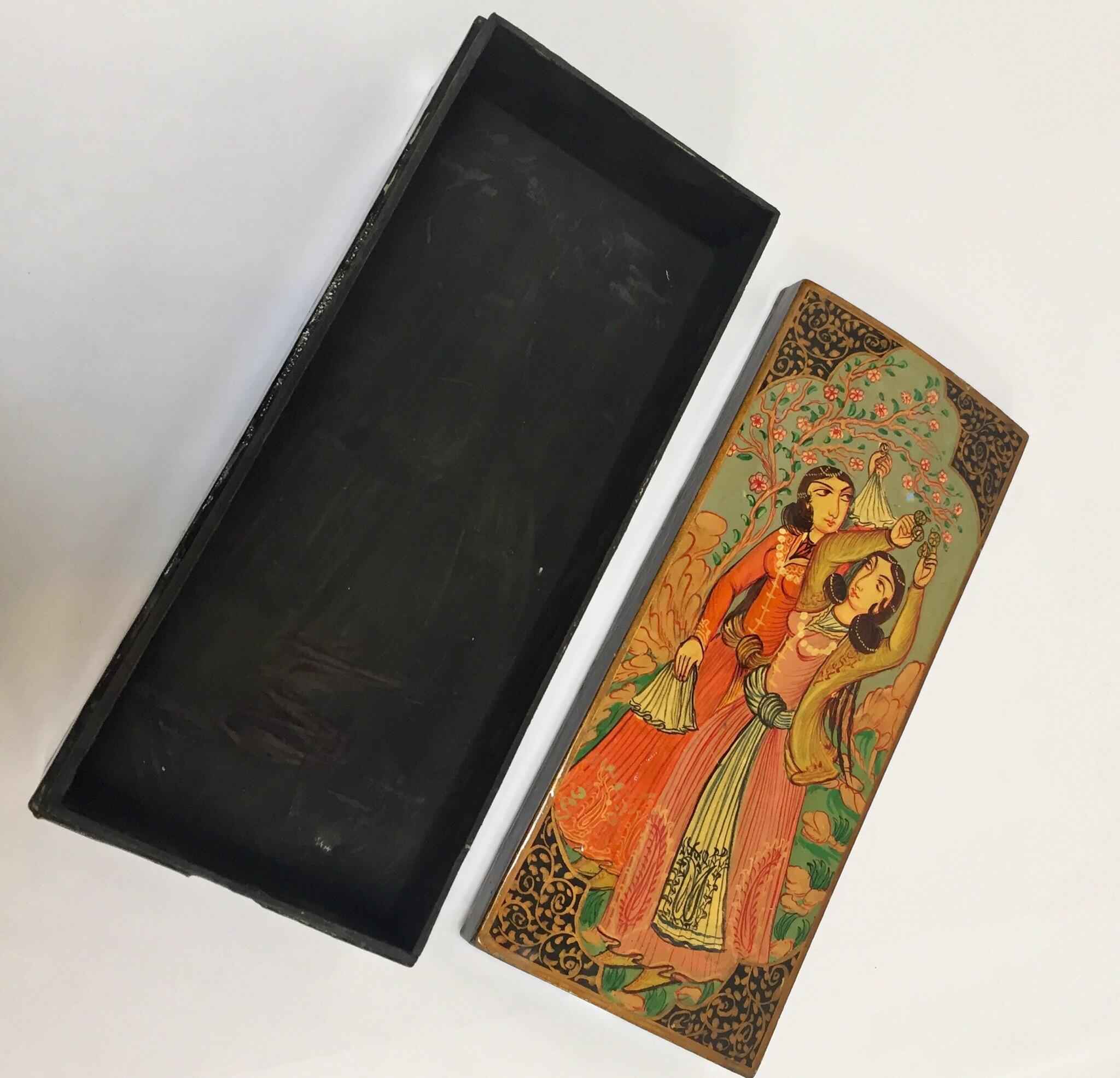 Hand painted lacquer pen box in rectangular shape with lid.
Decorated with a figural 17th century scene and floral designs on sides on black background.
Pen box hand painted with harem young girls wearing 17th century clothes playing and dancing
