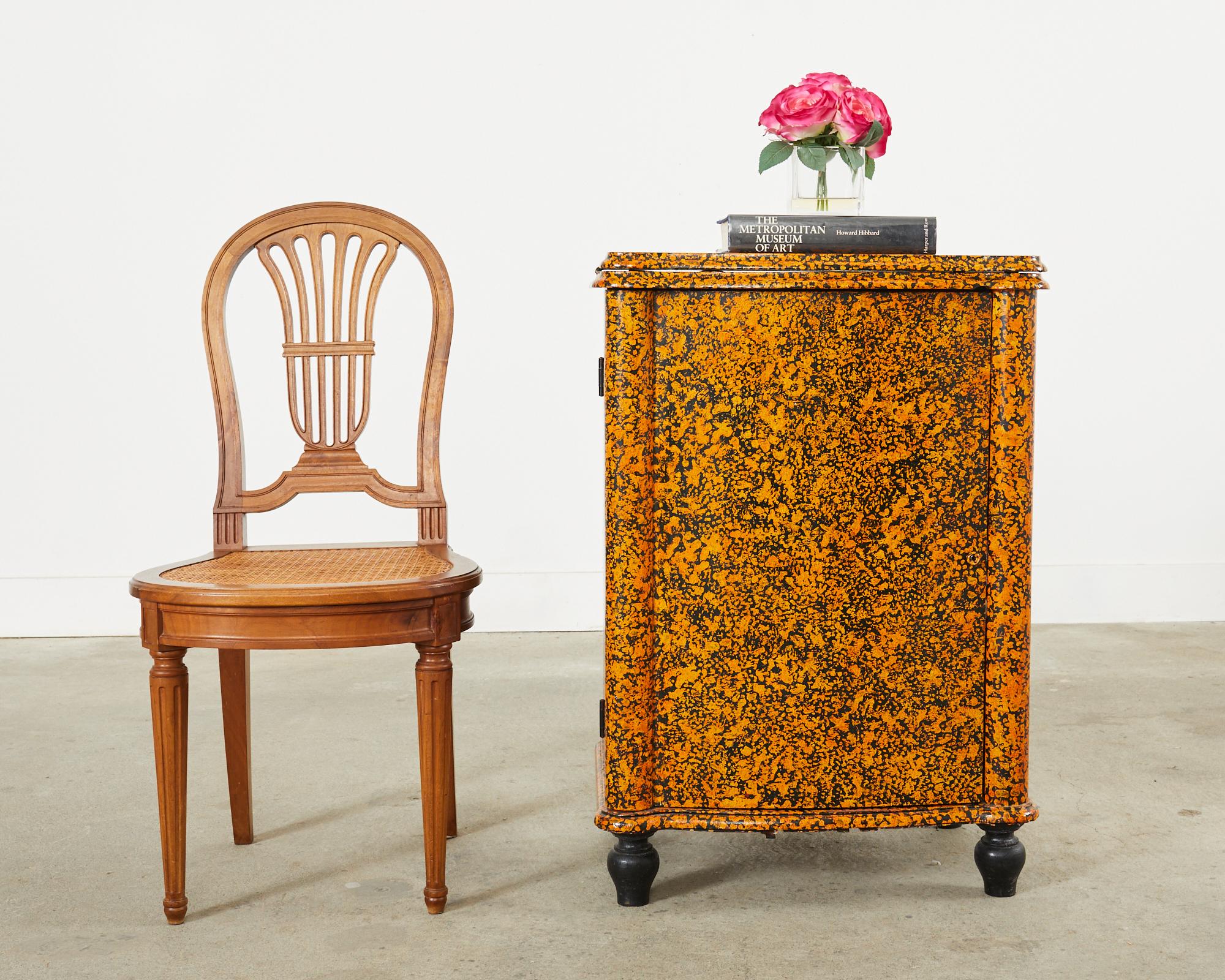Folk art sewing table that has been repurposed as a cupboard and lacquer speckled by artist Ira Yeager (American 1938-2022). The cupboard features a flip top over a wood case fronted by a large door. The inside has open storage area with small