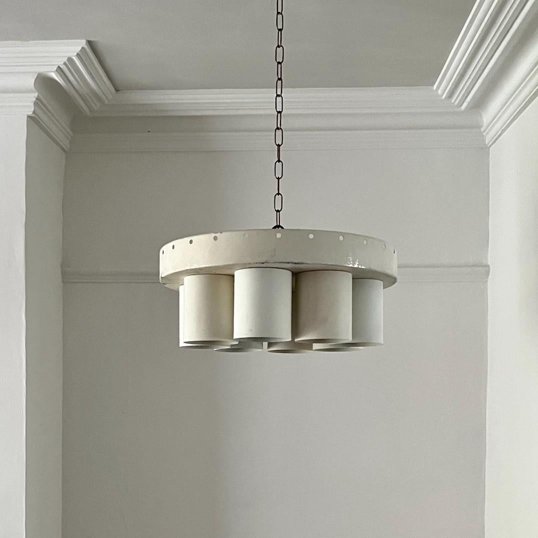 A simple circular light by Hans Agne Jakobsson, Sweden, mid-20th century.

The light is made of aluminium, lacquered off white, with 8 cylindrical tube down-lighters. The light is designed to be fitted to a ceiling hook and raised further into place