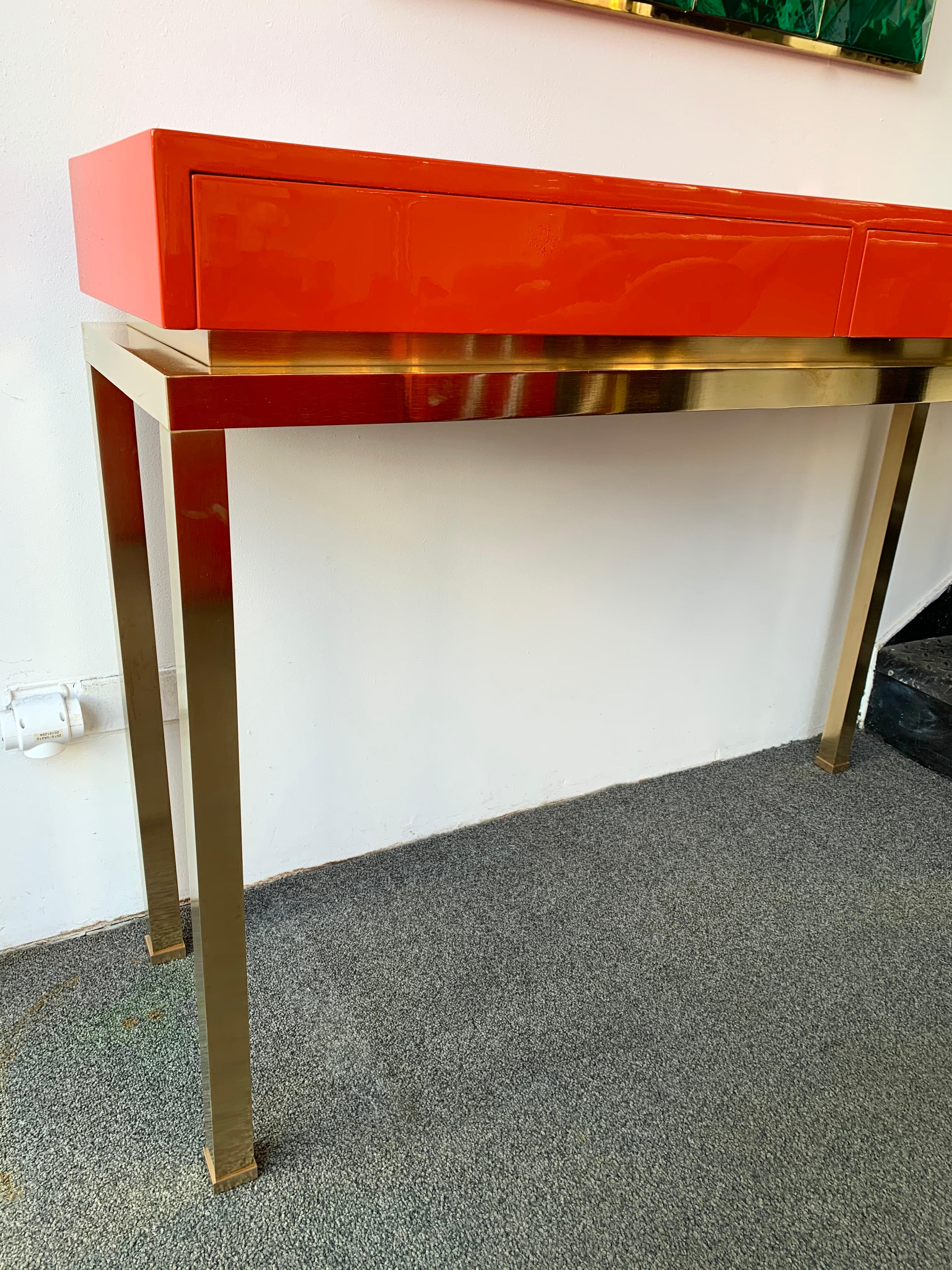 Console table orange coral lacquered wood with drawers, brass feet by Guy Lefèvre. Part of his production was presented by Maison Jansen during the 1970s. Famous design like Mahey, Willy Rizzo, Mario Sabot.