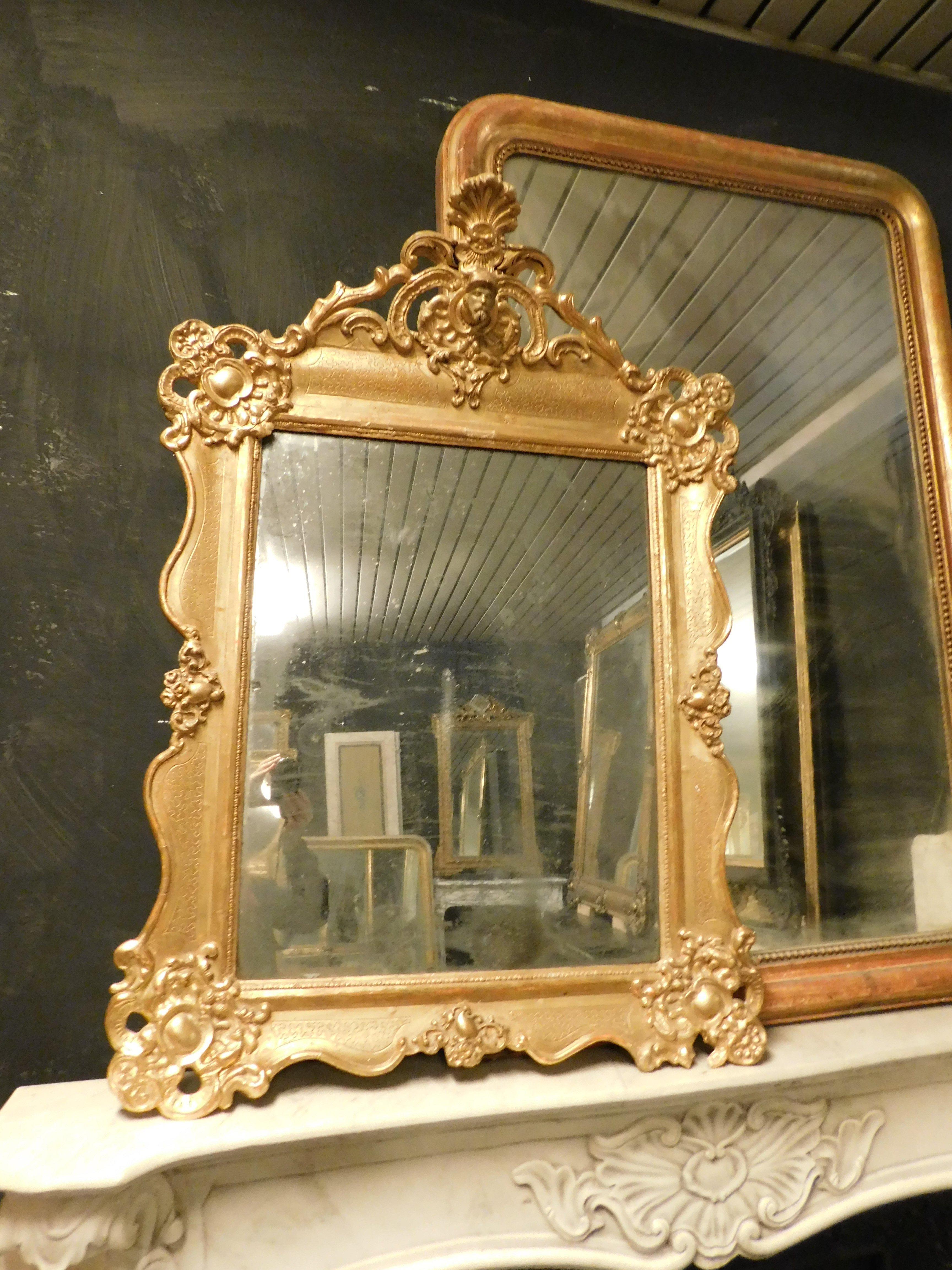 Espejo antiguo de madera lacada y dorada, ricamente tallado tanto en el marco como en el arco superior, Tiene esculturas y una moldura facial. Original del siglo XIX y de origen italiano. Medidas exteriores cm An 86 x Al 120