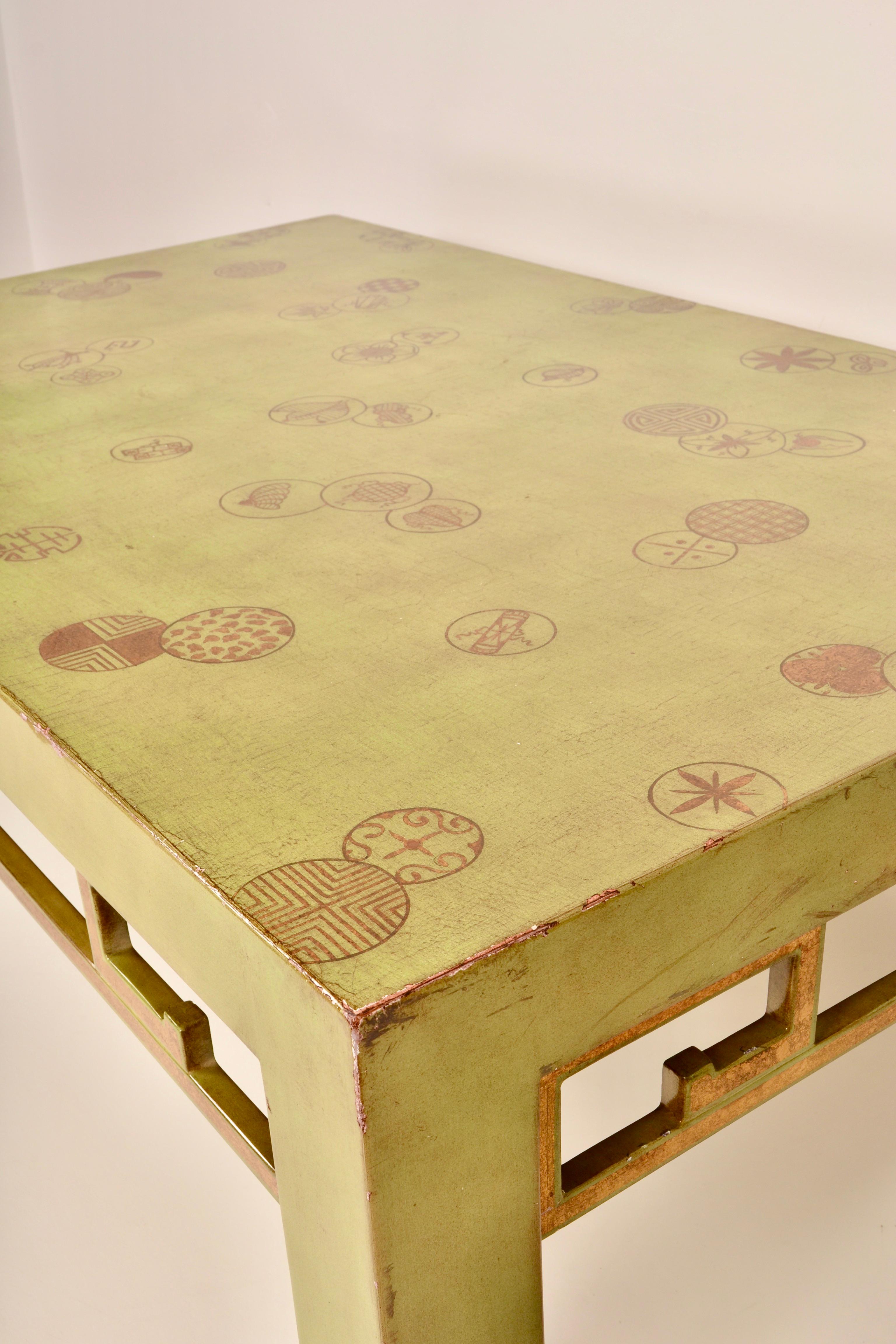 Wonderful color on this lacquered Chinoiserie-form cocktail table. Decorated with quirky, painted gold designs. Gold painted details on decorative stretchers. Great size and in very nice condition.