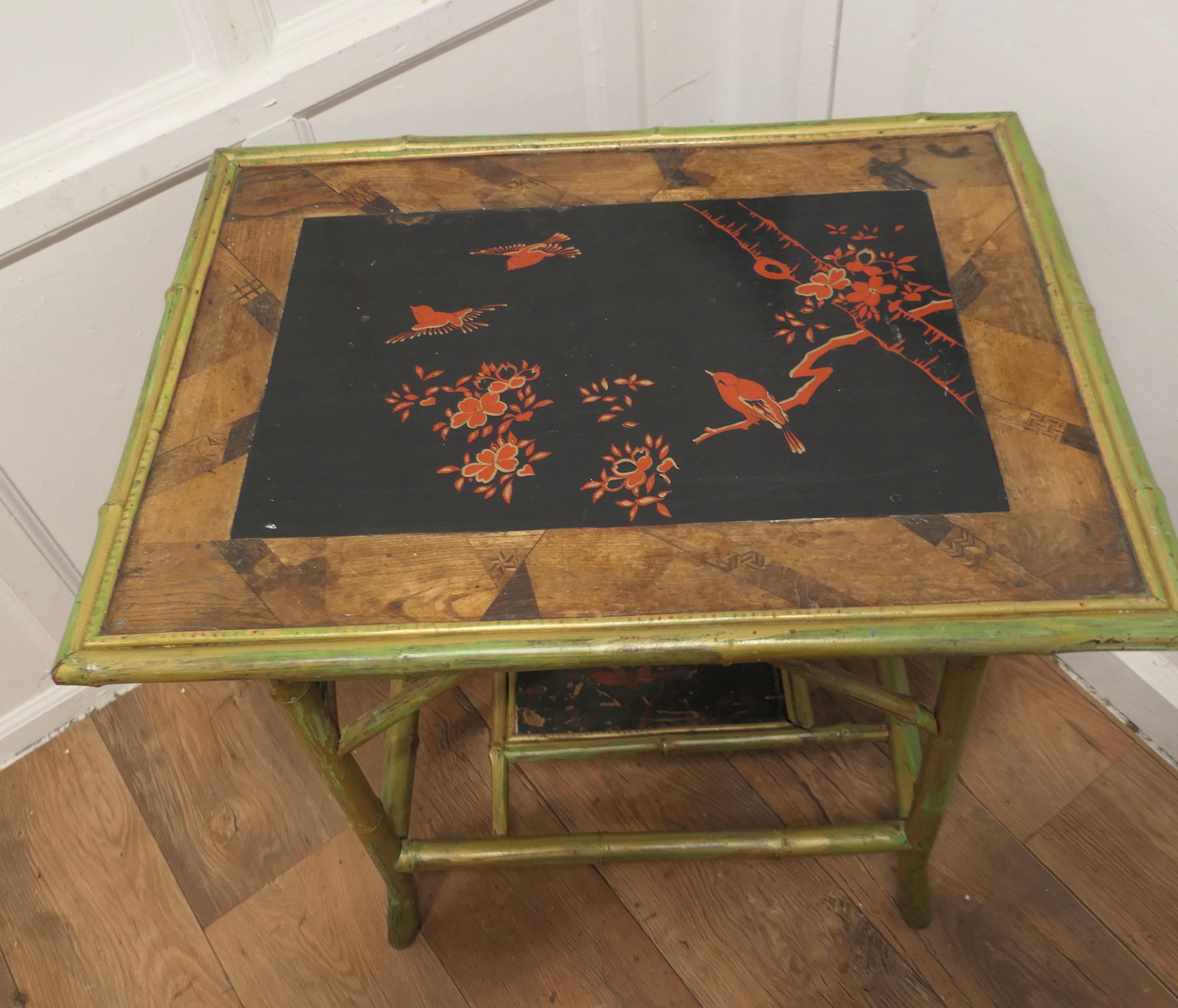 Lacquered Chinoiserie Bamboo Occasional Table  

This is a late 19th century piece, the table has 2 tiers, the upper tier has a marquetry border surrounding a black lacquered panel decorated with birds and flowers
The bamboo has a gold/green