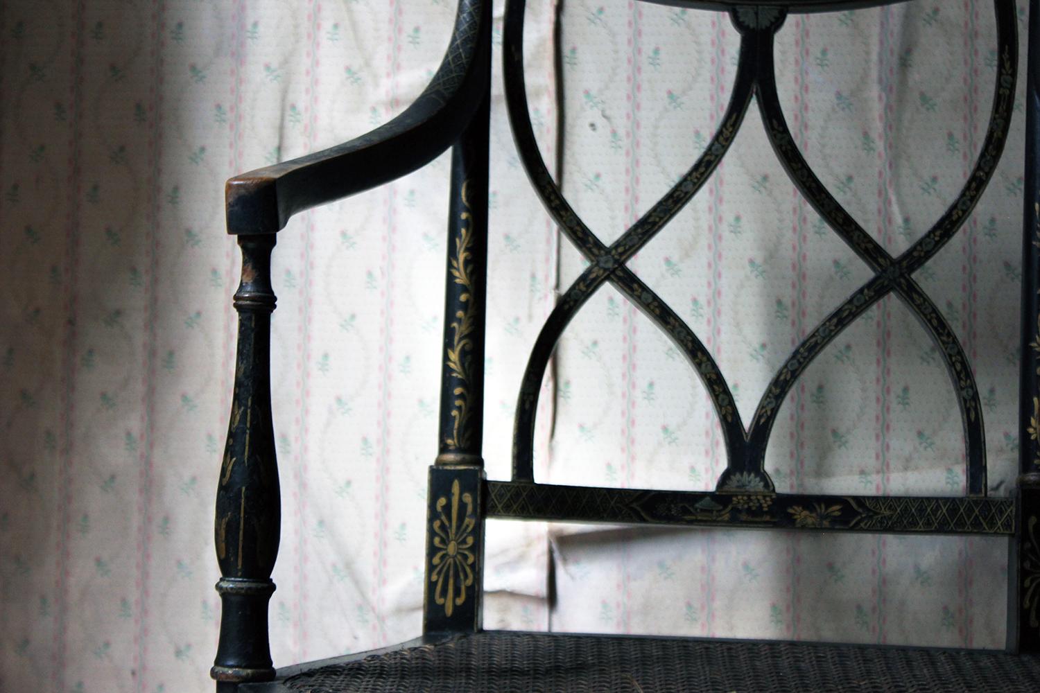 The early 20th century japanned lacquered beech elbow chair, in the Regency taste with chinoiserie style decoration, and with a Sheraton style latticed back, on baluster and fluted turned front legs, the whole by Druce and Co., Ltd. of Baker Street,