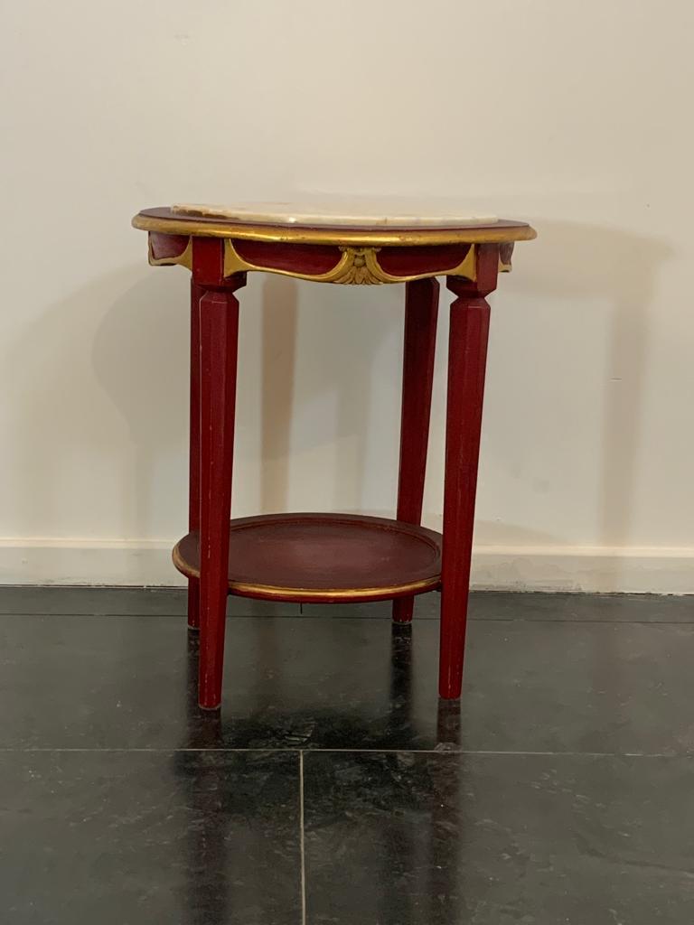Mesa de centro lacada en rojo cardenal, detalles recubiertos de pan de oro, tablero de mármol blanco veteado de amarillo.
Se incluye el embalaje con plástico de burbujas y cajas de cartón. Si se necesita el embalaje de madera (cajas o cajones