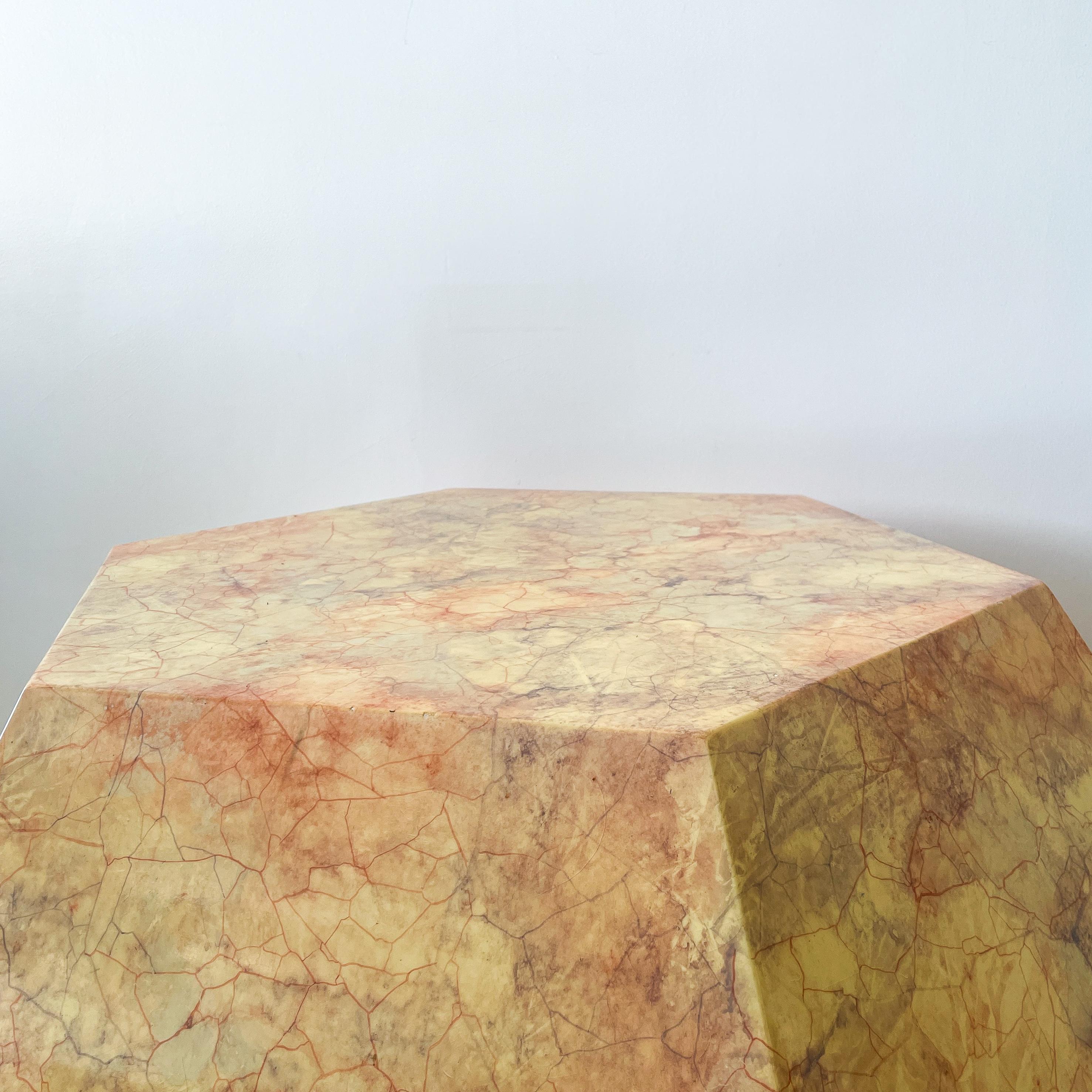 Jewel-like hexagonal faux marble coffee table. Warm ivory color with rose and amethyst veining. 

The construction appears to be wood, which has been painted and sealed with a clear coat. The finished surface is glossy.

Wear consistent with age and