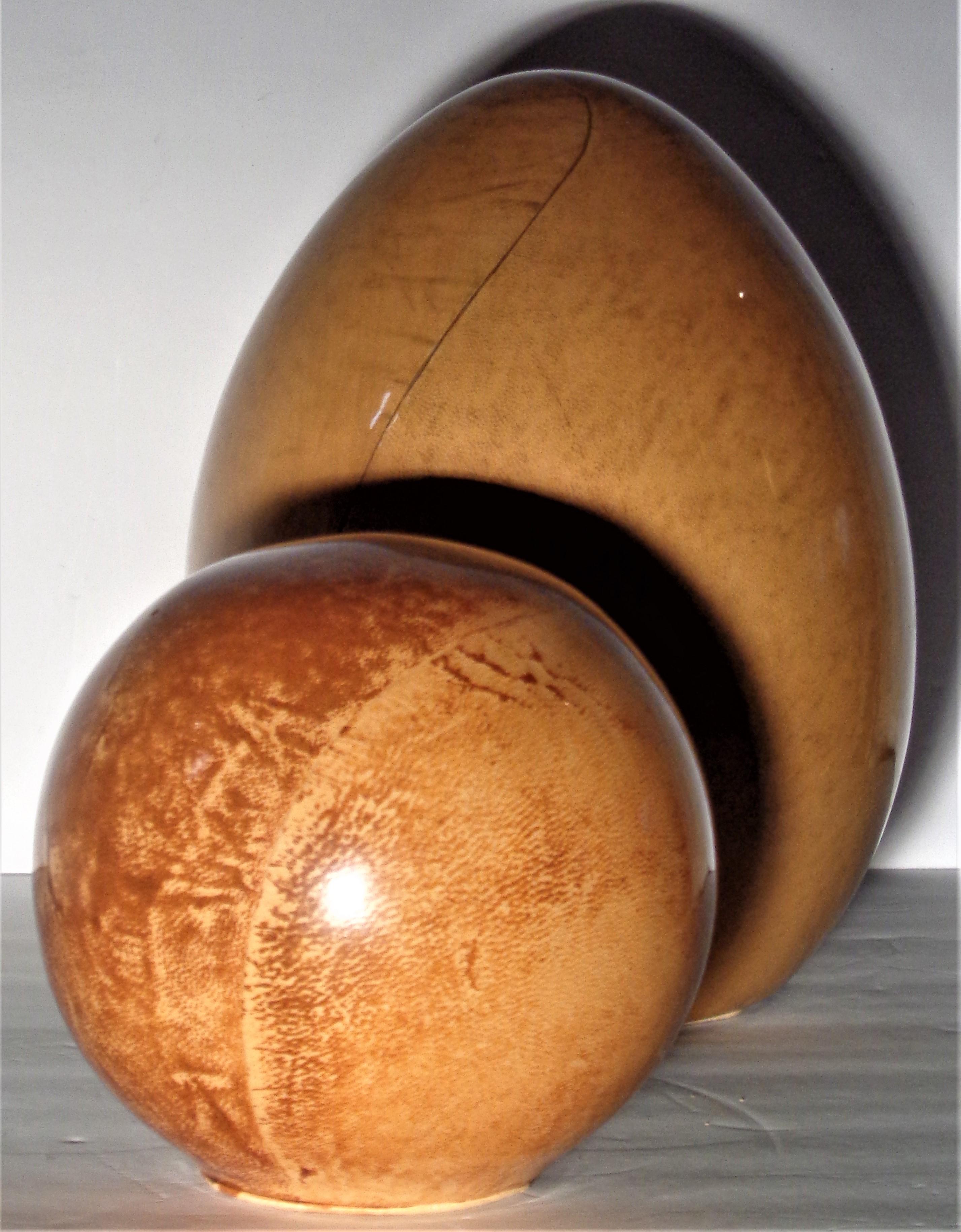 Lacquered goatskin decorative sculpture objects in the manner of Karl Springer, circa 1970's. Large egg form measures 10 inches high x 7 1/2 inches across widest point. Sphere measures 6 inches high x 6 inches across. Great all original glowing