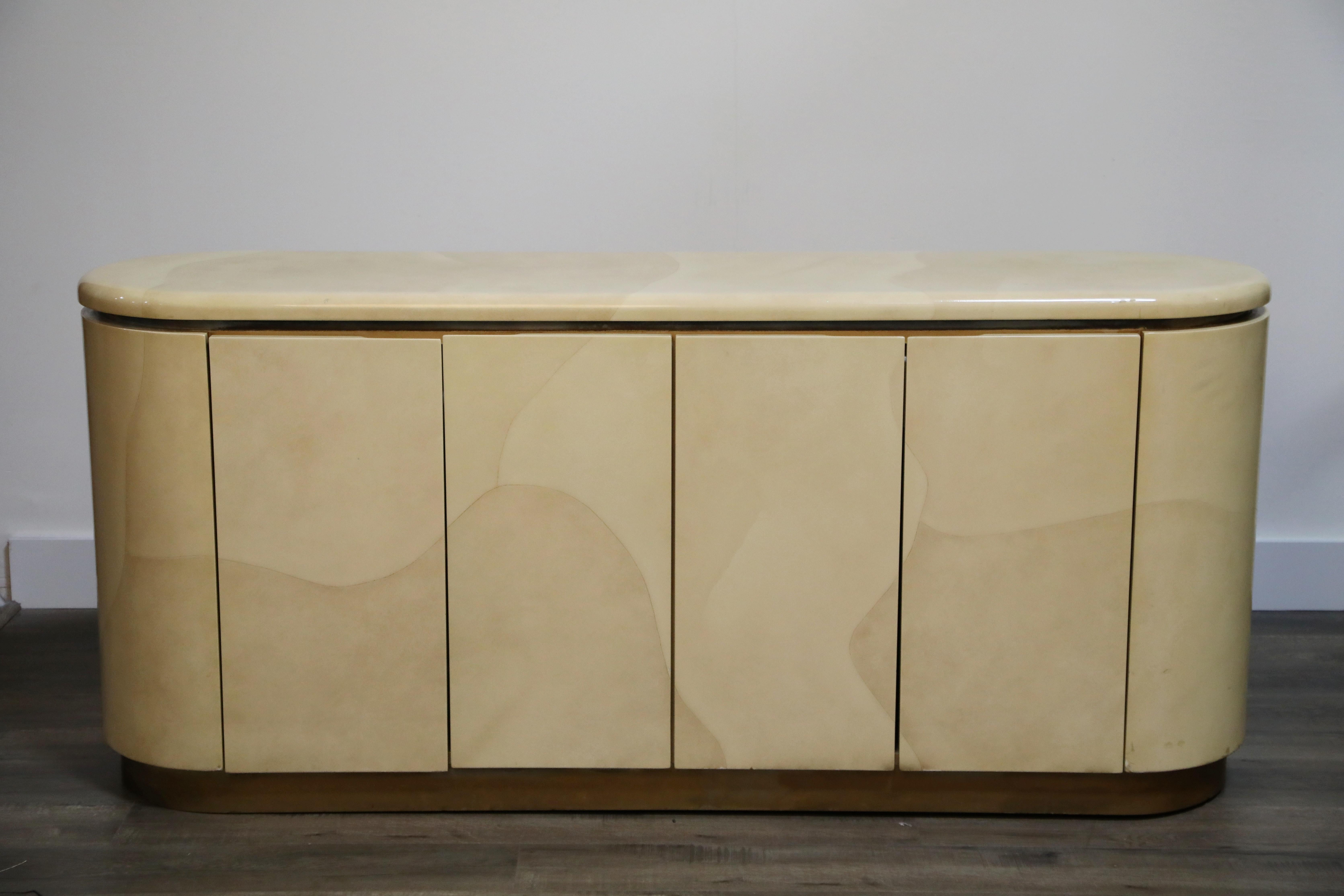A lovely lacquered goatskin sideboard or credenza, with beautiful grain detail in the goatskin hides, in the style of Karl Springer and Steve Chase, circa 1970s. With a finished back it can also be used as a room divider. 

Four doors open to