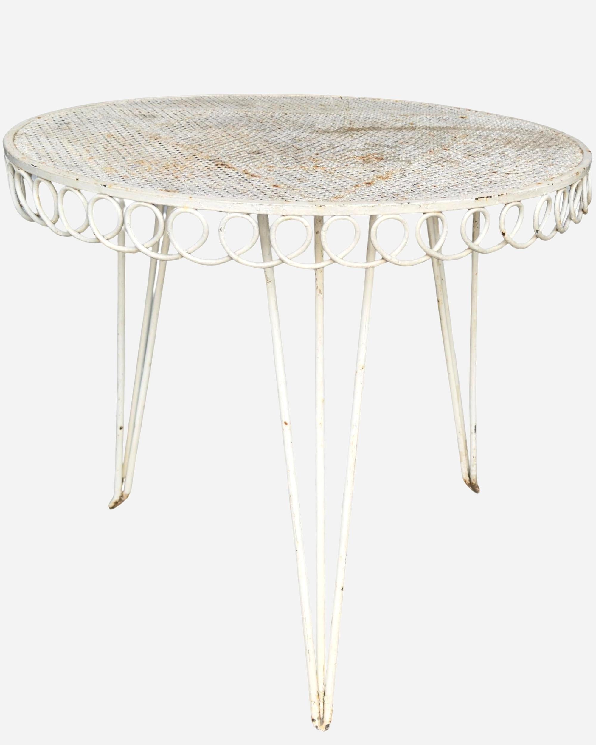 Tavolino da giardino rotondo in ferro battuto laccato con piano in lamiera forata a motivi geometrici.
Il bordo è decorato come il modello 