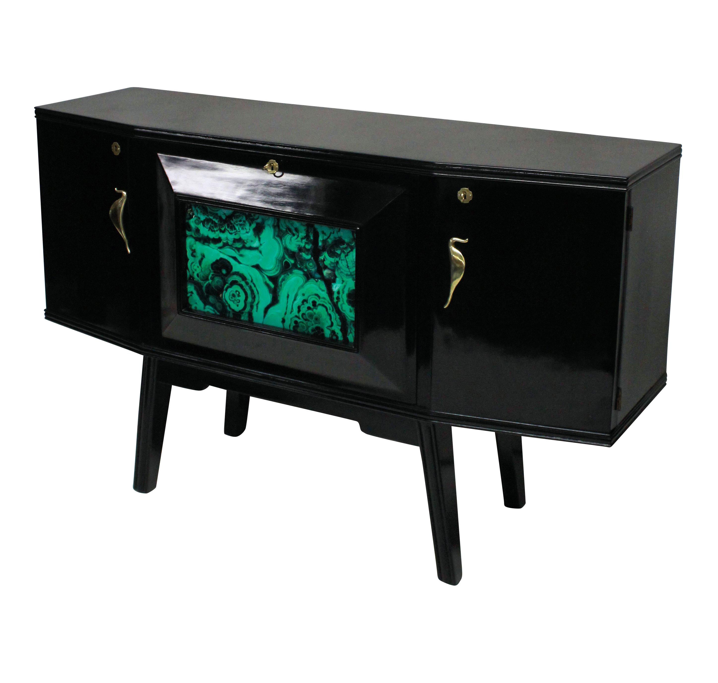 A stylish Italian bar credenza of interesting angular design in black lacquer with sepele wood interior, with brass hardware and a faux malachite central panel and mirrored interior.

 