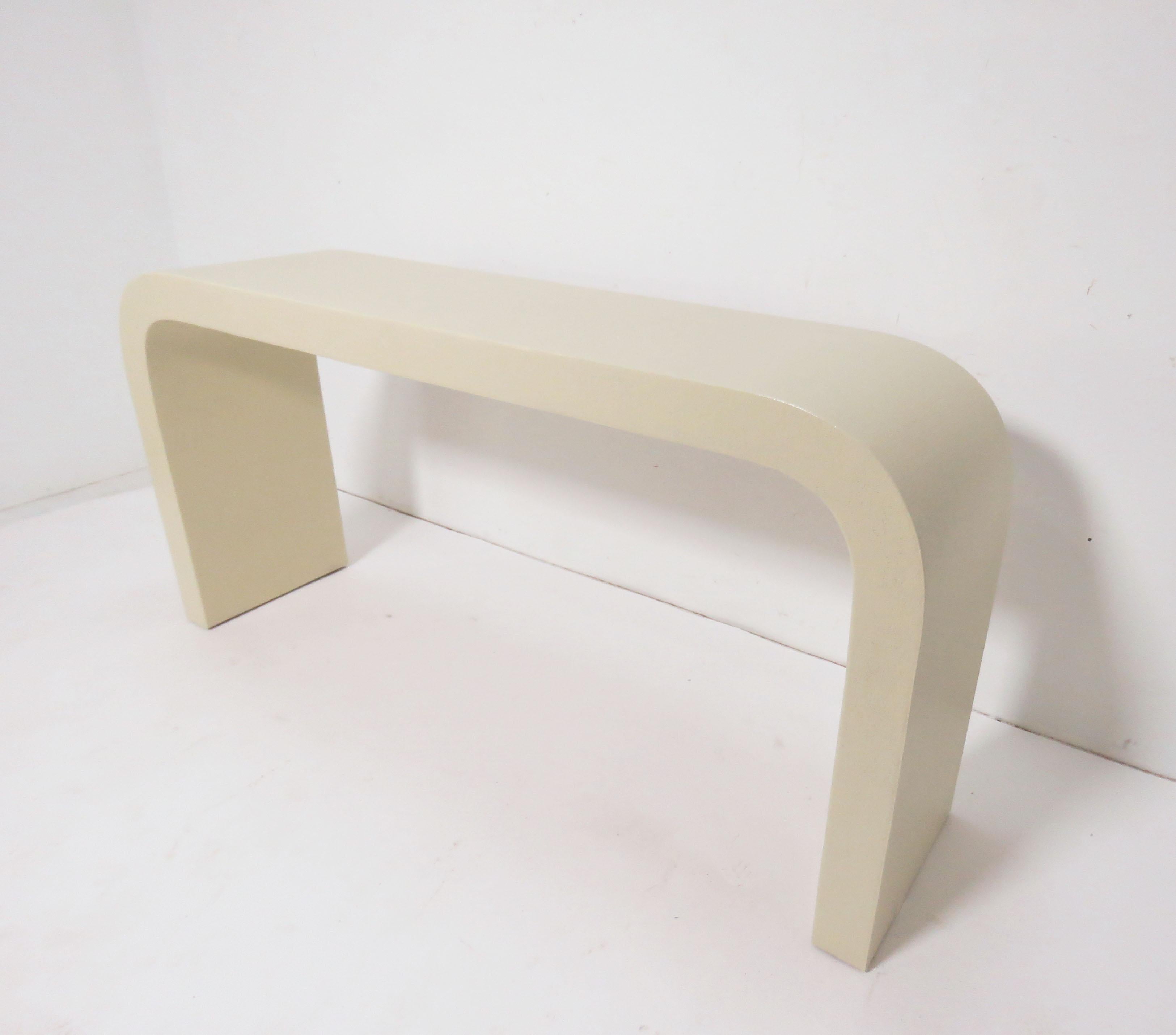 An original 1970s era, linen wrapped waterfall console table in the manner of Karl Springer or Jay Spectre.