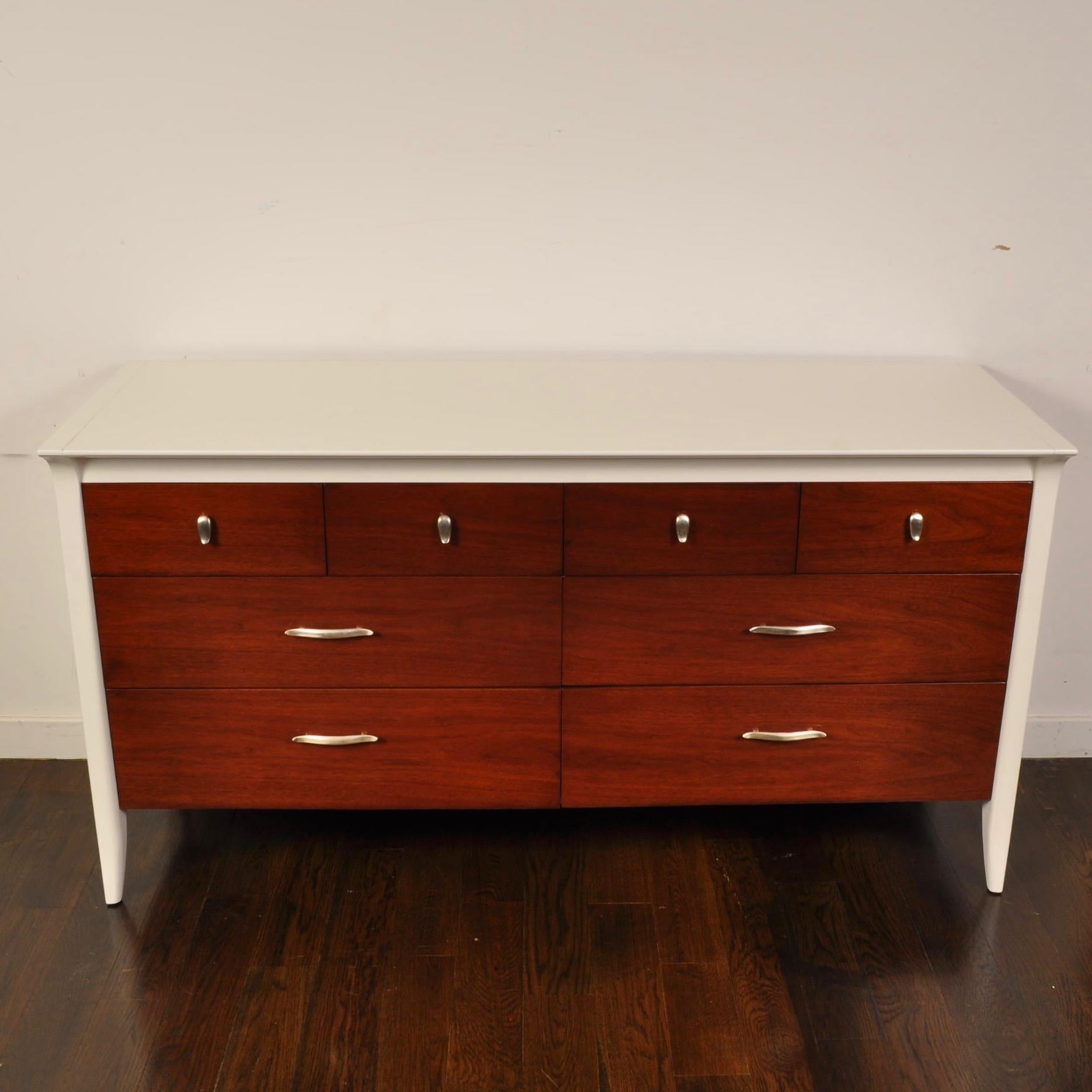 Part of the Profile line designed by John Van Koert for Drexel, this nightstand and matching 8 drawer dresser has been refinished in a two-toned walnut and satin finish white dove lacquer.