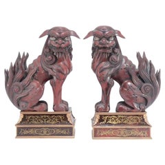 Des chiens Foo ou lions gardiens en bois sculpté de la période Meiji sur des supports en boulle