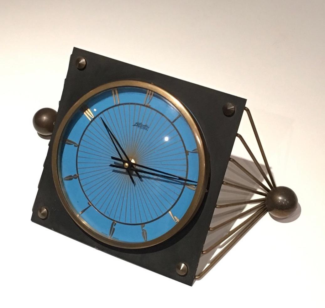 This clock is made of lacquered metal, brass and curved glass. This is a French work. Circa 1950.