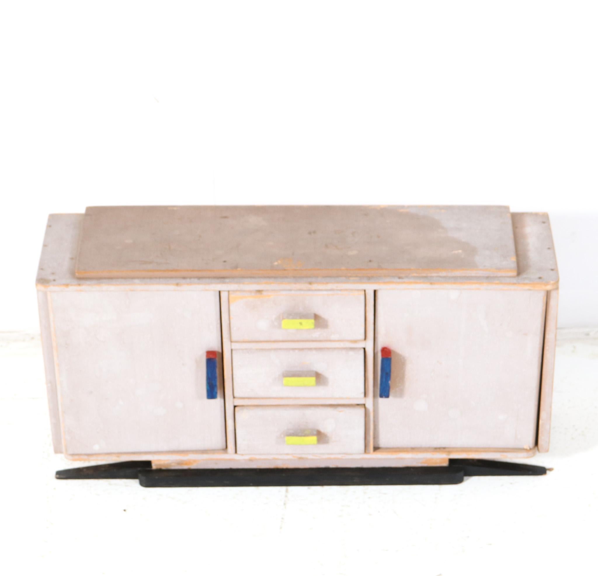 Stunning and rare Art Deco Modernist children's furniture credenza.
Striking Dutch design from the 1930s.
Original lacquered plywood base with hand-painted multi-colored handles.
This wonderful Art Deco Modernist children's furniture credenza is in