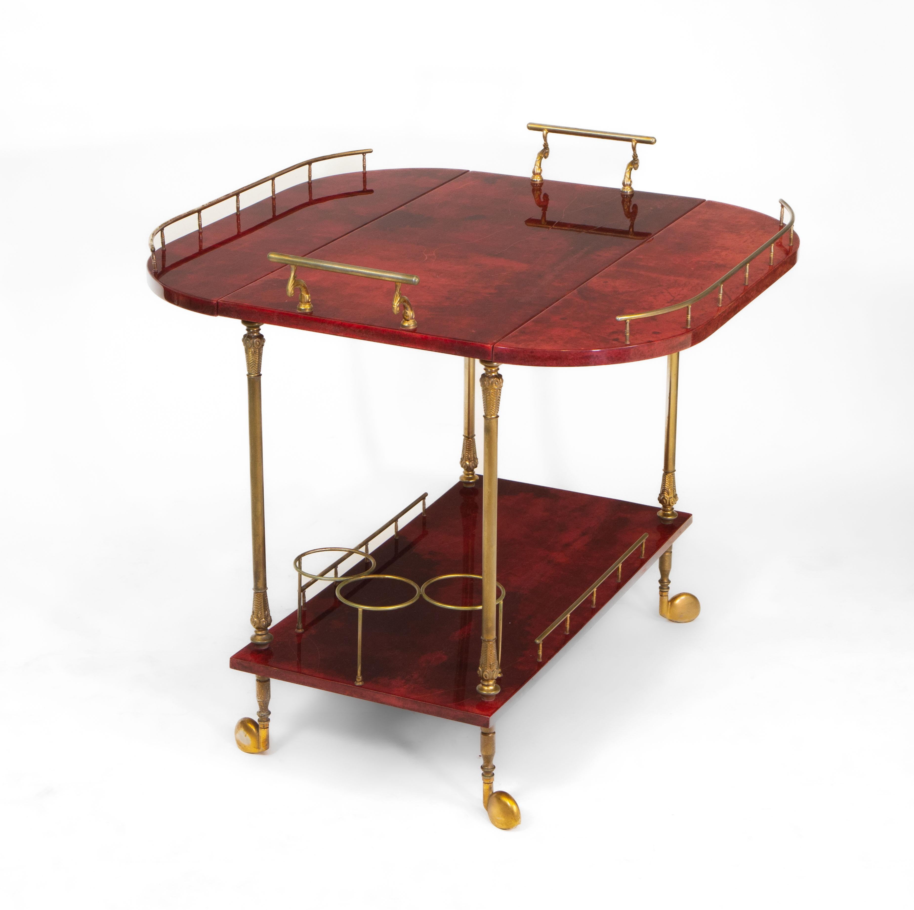 A fabulous mid-century Italian two-tier rich red coloured parchment vellum and gilt metal drinks trolley, designed by Aldo Tura (1909–1963). Labelled: Tura Milano. Circa 1950's.

Aldo Tura began manufacturing his signature furniture in the 1930s.