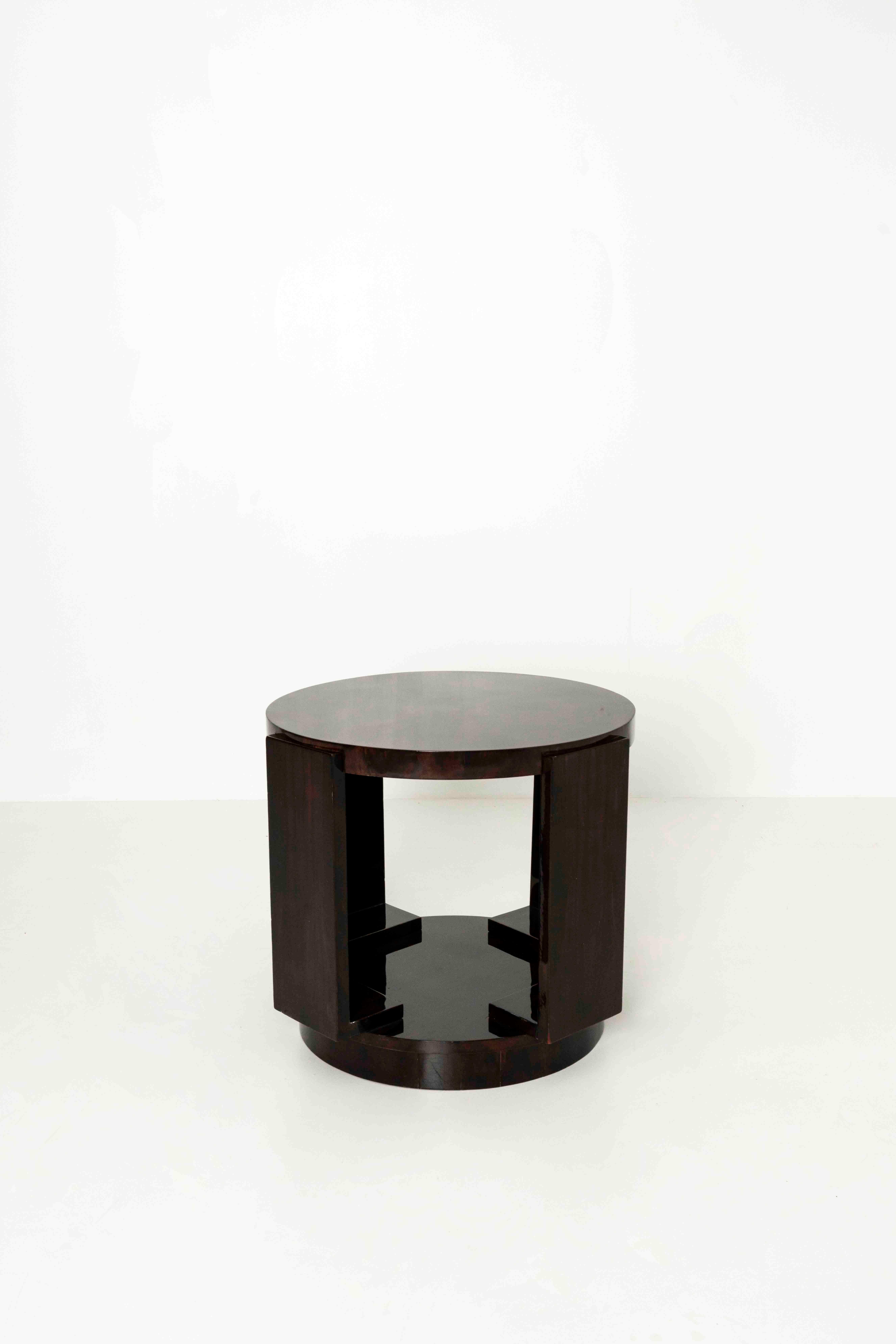 Nice dark brown lacquered Art Deco coffee table from France, the 1930s. This round coffee table has a nice design with four legs leading from top to bottom with very visible connections. The table is in good condition with normal wear and tear due