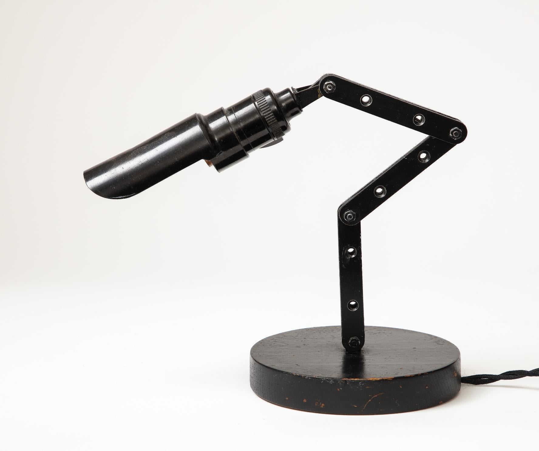 Lampe de bureau/de table articulée d'aspect industriel. Peut être réglé pour pointer vers le haut ou vers le bas.