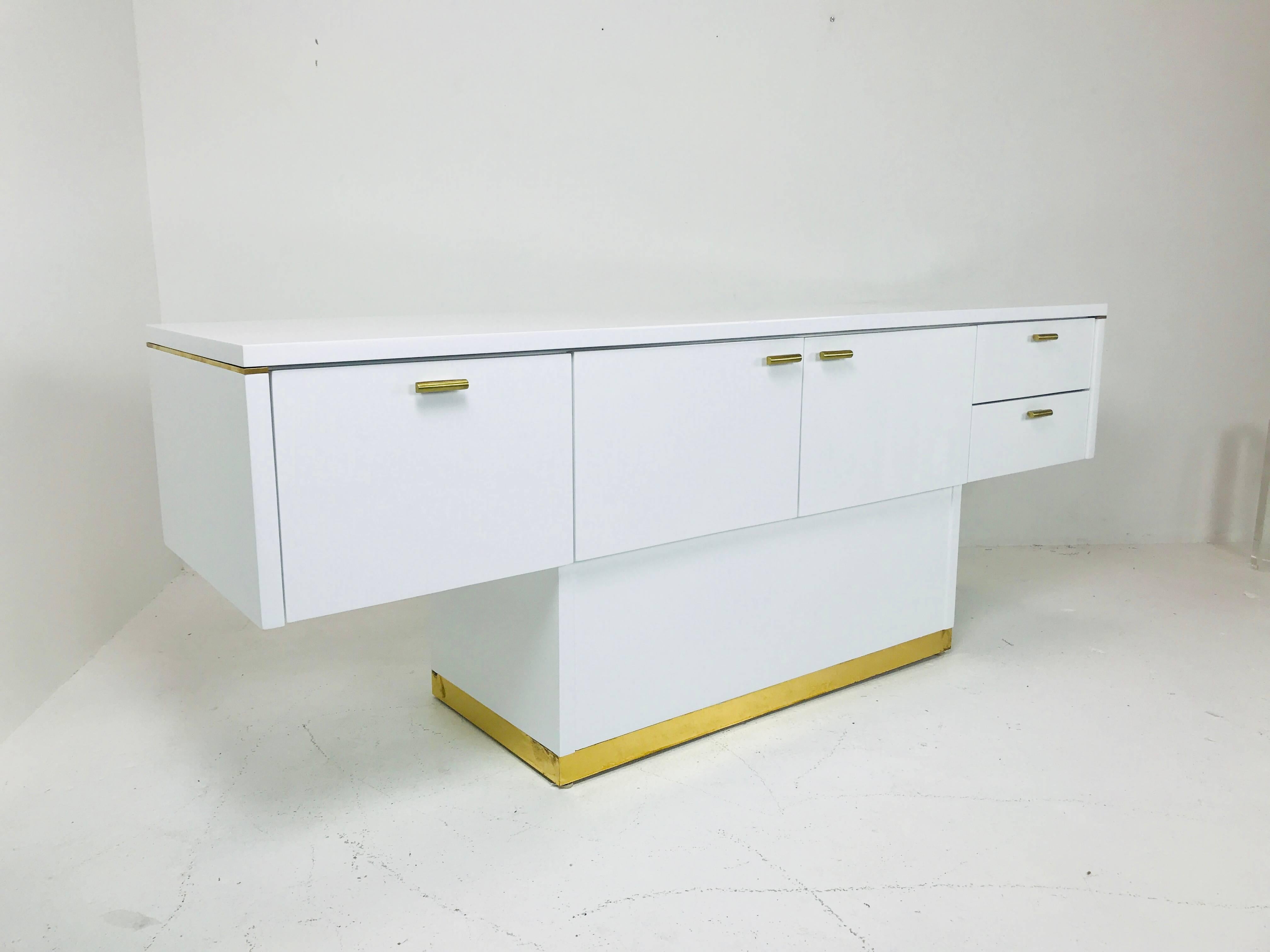 Lacquered T-Console/sideboard with brass accents. Storage includes three door with open storage and two drawers.

Dimensions: 
76
