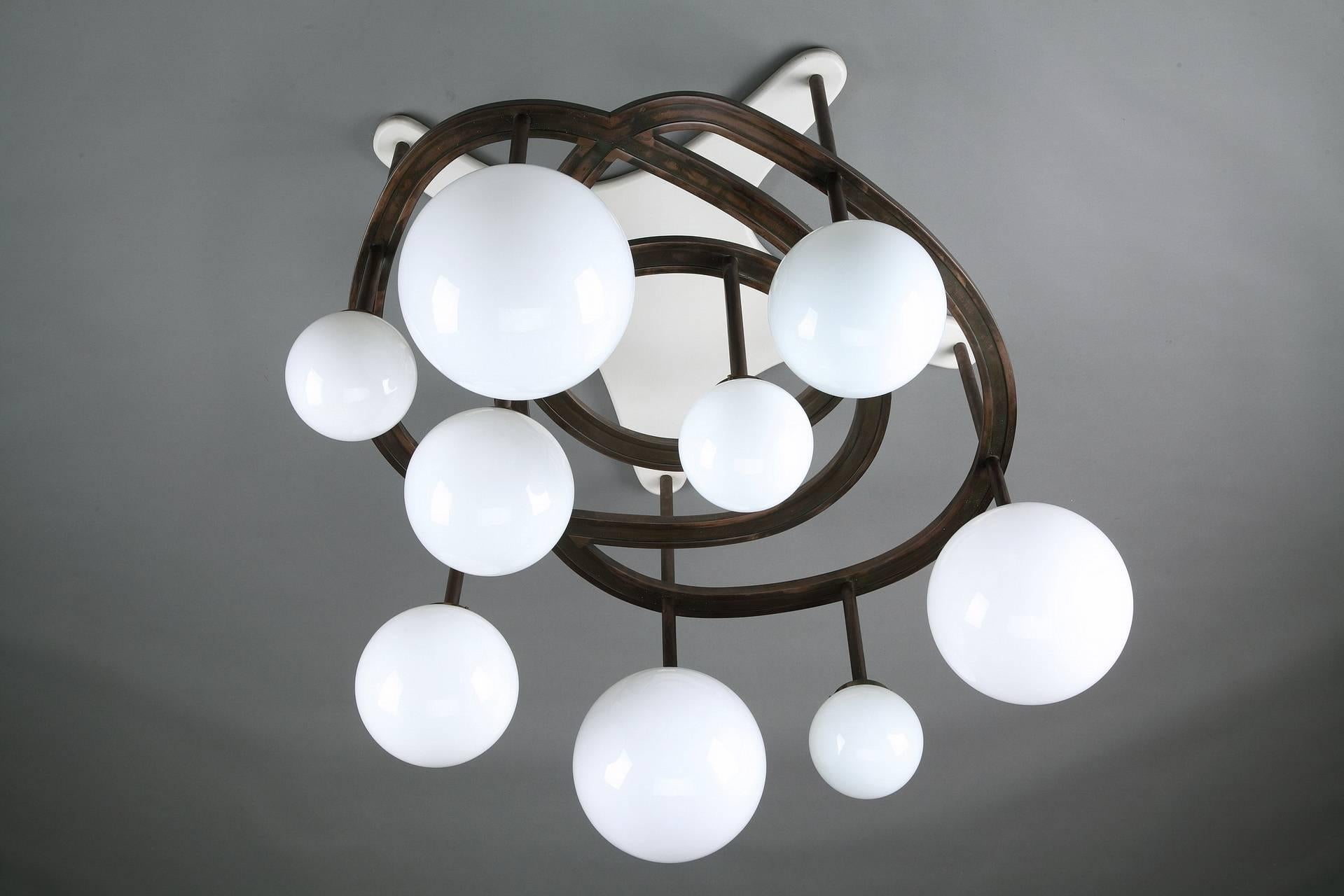 Exquisite chandelier, with white lacquered wood base and copper structure. It has 9 arms decorated with white opaline globes. A sculptural shape, full of elegance and modernity. Unique ceiling lamp designed by Yves Faucheur (French, 1924-1985) for