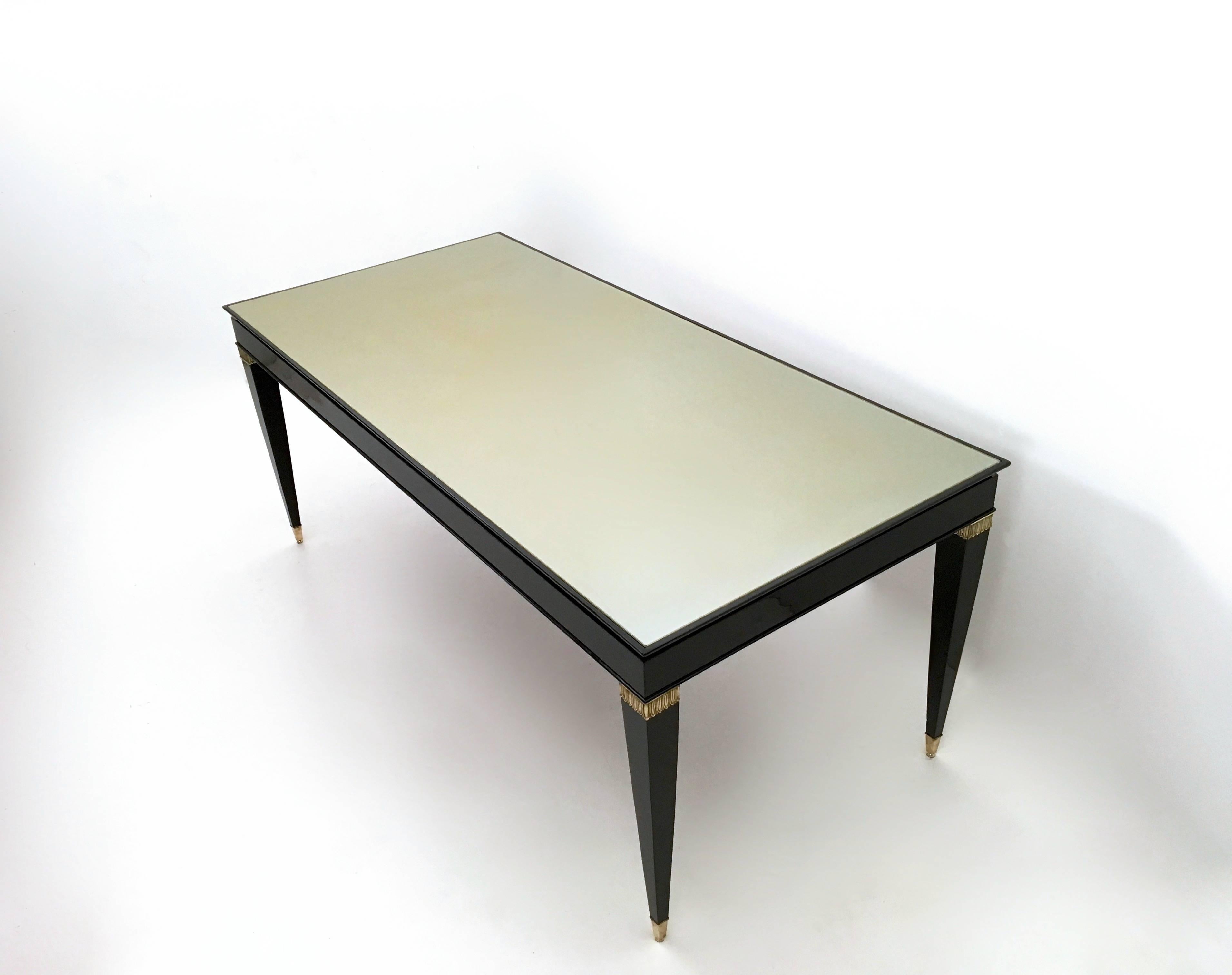 Hergestellt in Italien, 1950er Jahre.
Dieser Tisch ist aus schwarz lackierter Buche gefertigt und verfügt über Fußkappen und Details aus Messing sowie eine taupefarbene, hinterlackierte Glasplatte.
Da es sich um einen Vintage-Artikel handelt, kann
